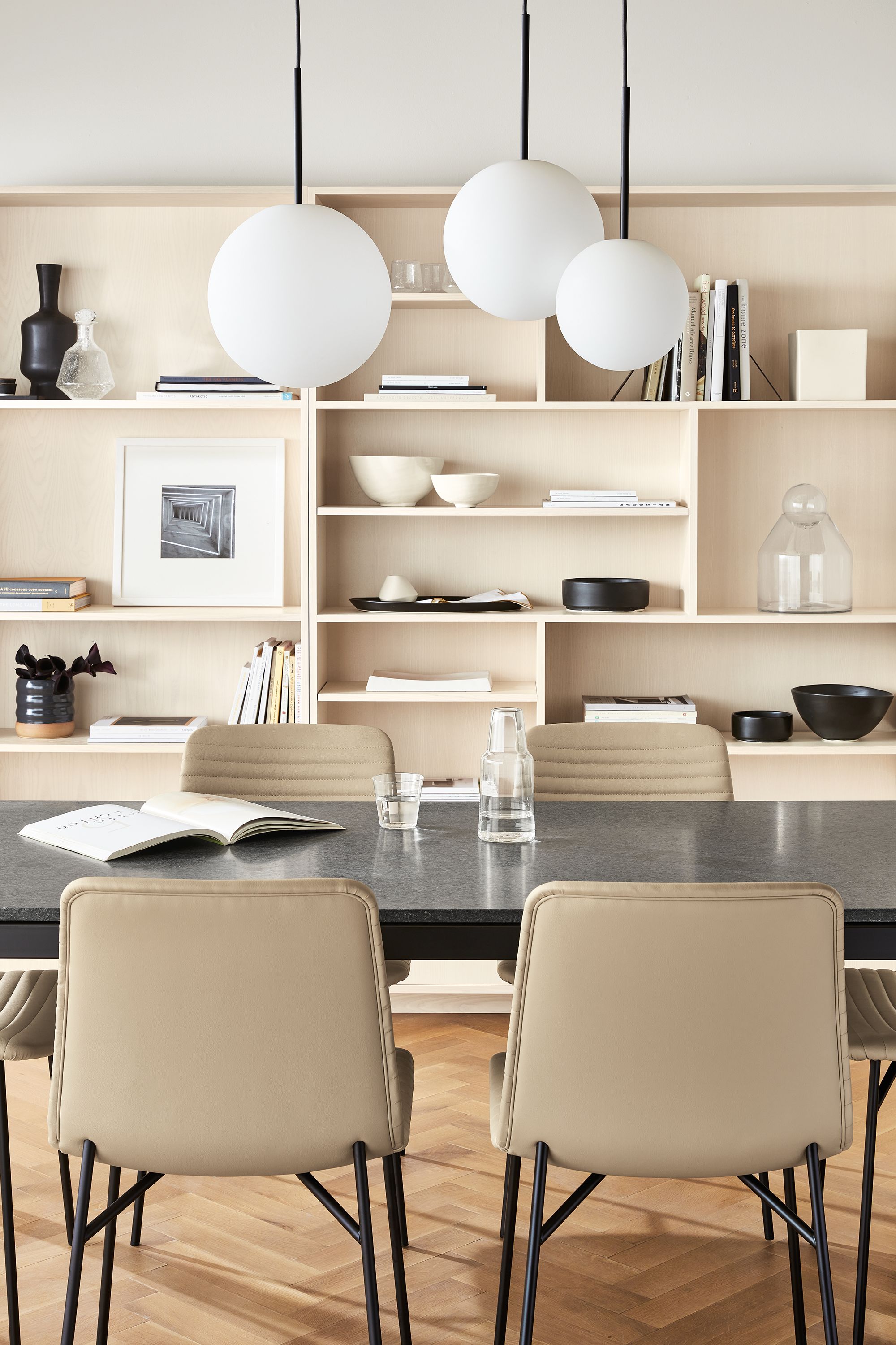 Room setting with Orbit pendants and Parsons table with Keaton bookcases in Sand.