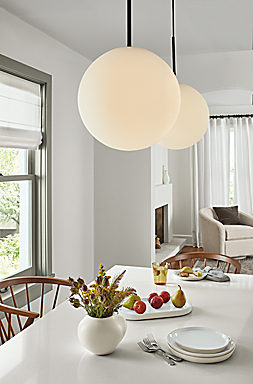 dining room with two orbit pendants above white quartz table.