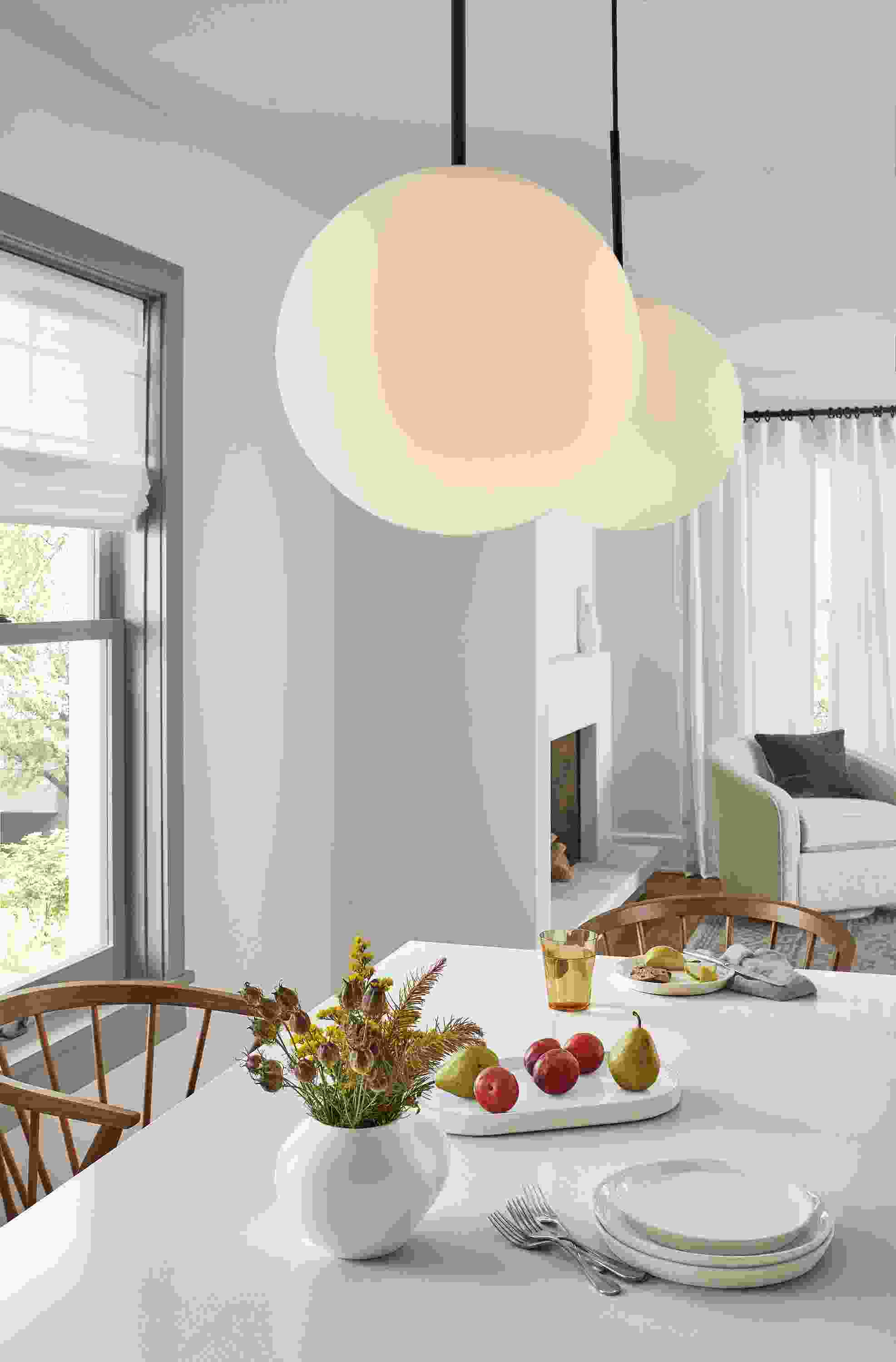 Dining room with two Orbit pendants above a Linden table with white quartz top.