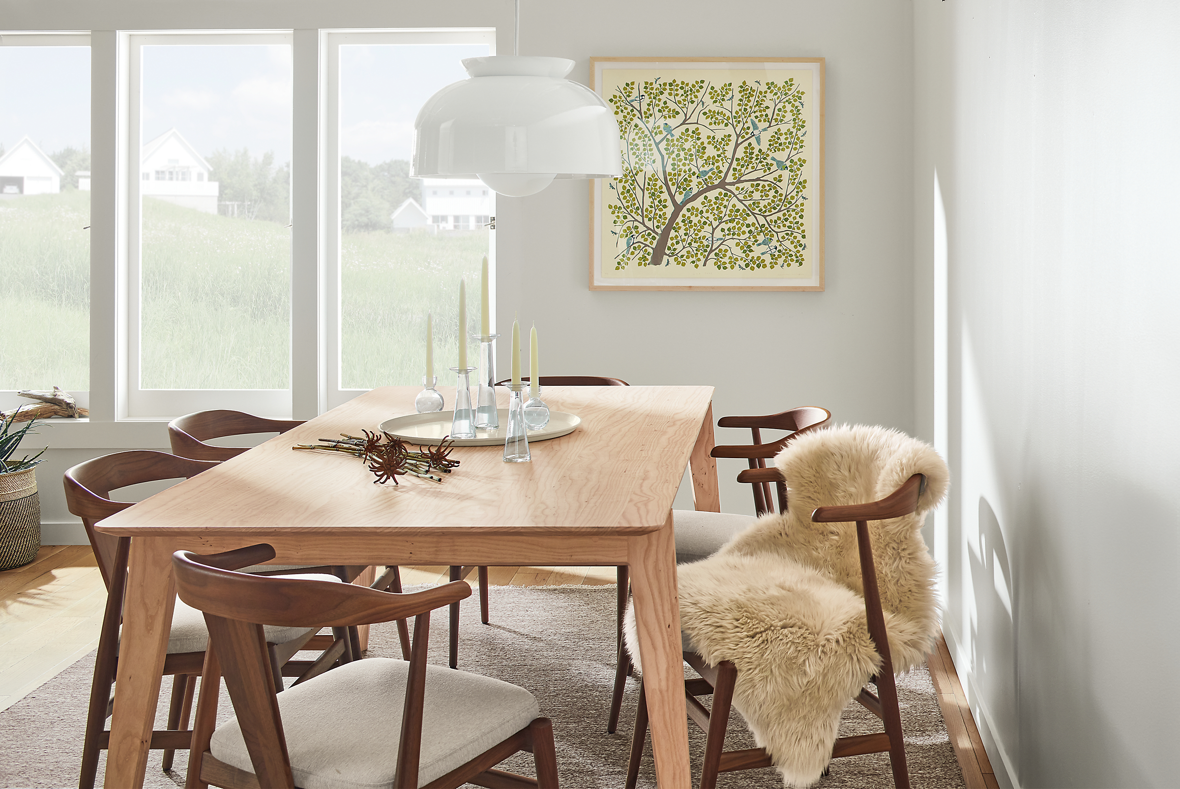 Room setting with an Orlin Dining Table and Evan Arm Chairs with a Bray pendant in white.
