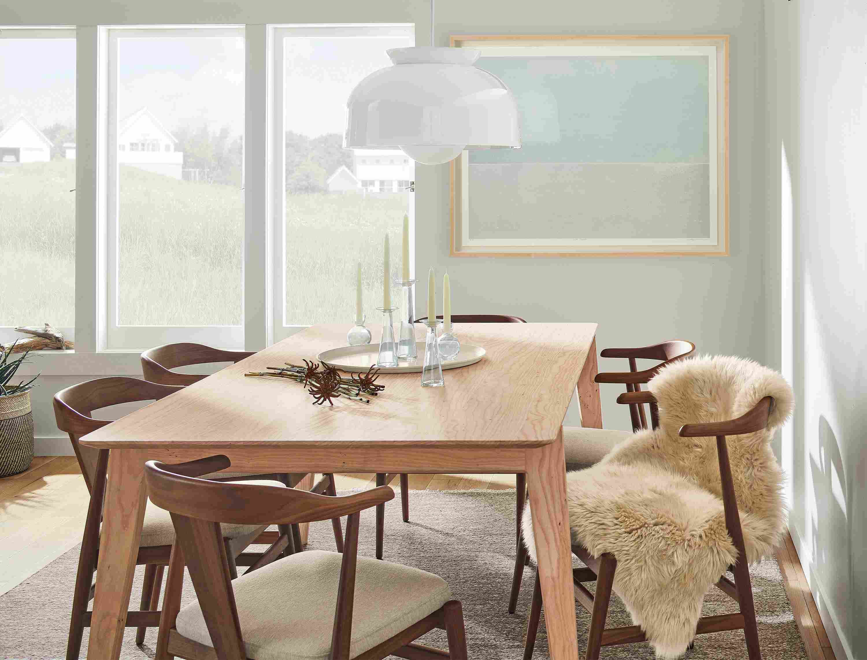 Dining room with Orlin 80 by 40-inch table in ash with Evans arm chairs in walnut with Myers Taupe fabric and Bray pendant in white.