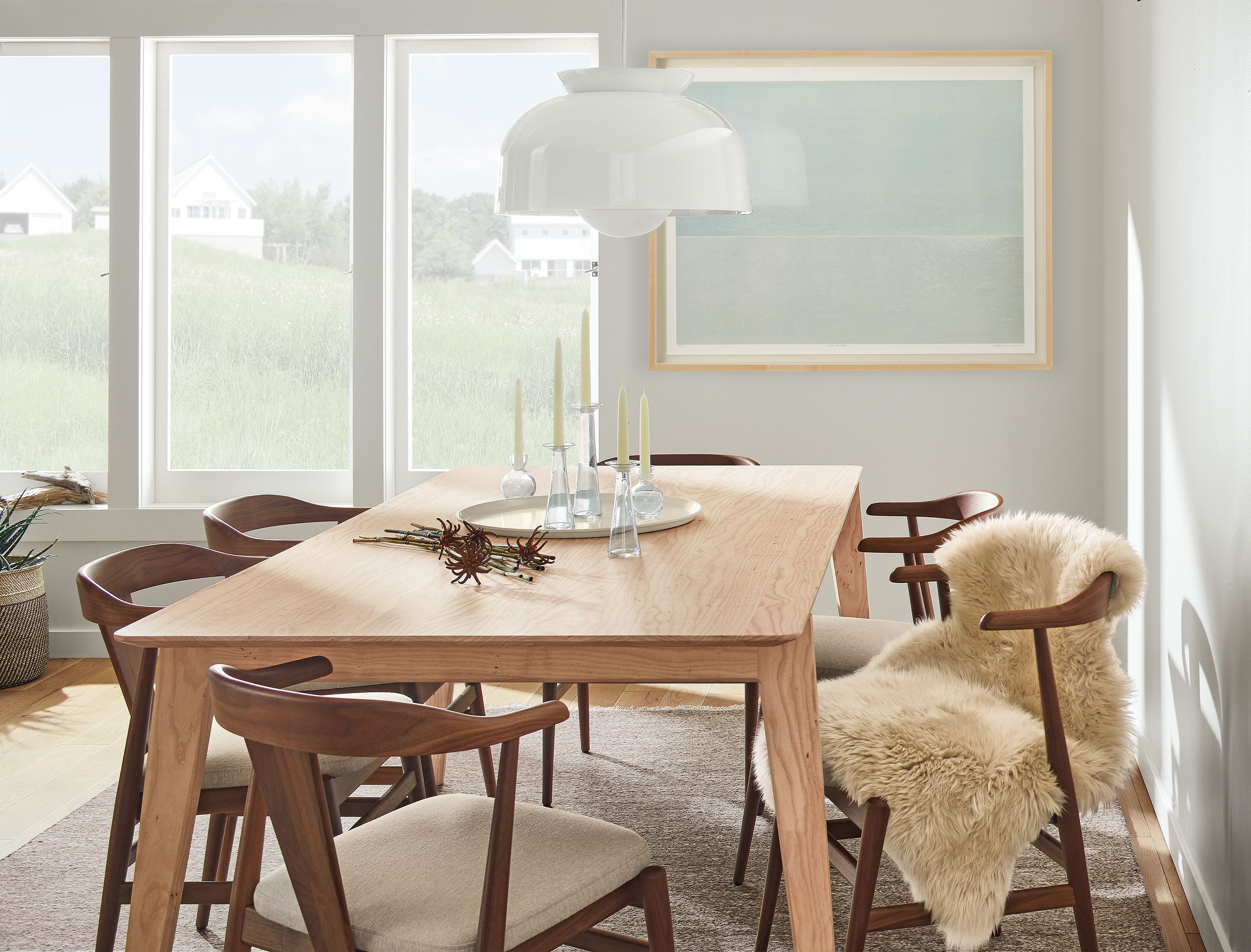 Dining room with Orlin 80 by 40-inch table in ash with Evans arm chairs in walnut with Myers Taupe fabric and Bray pendant in white.