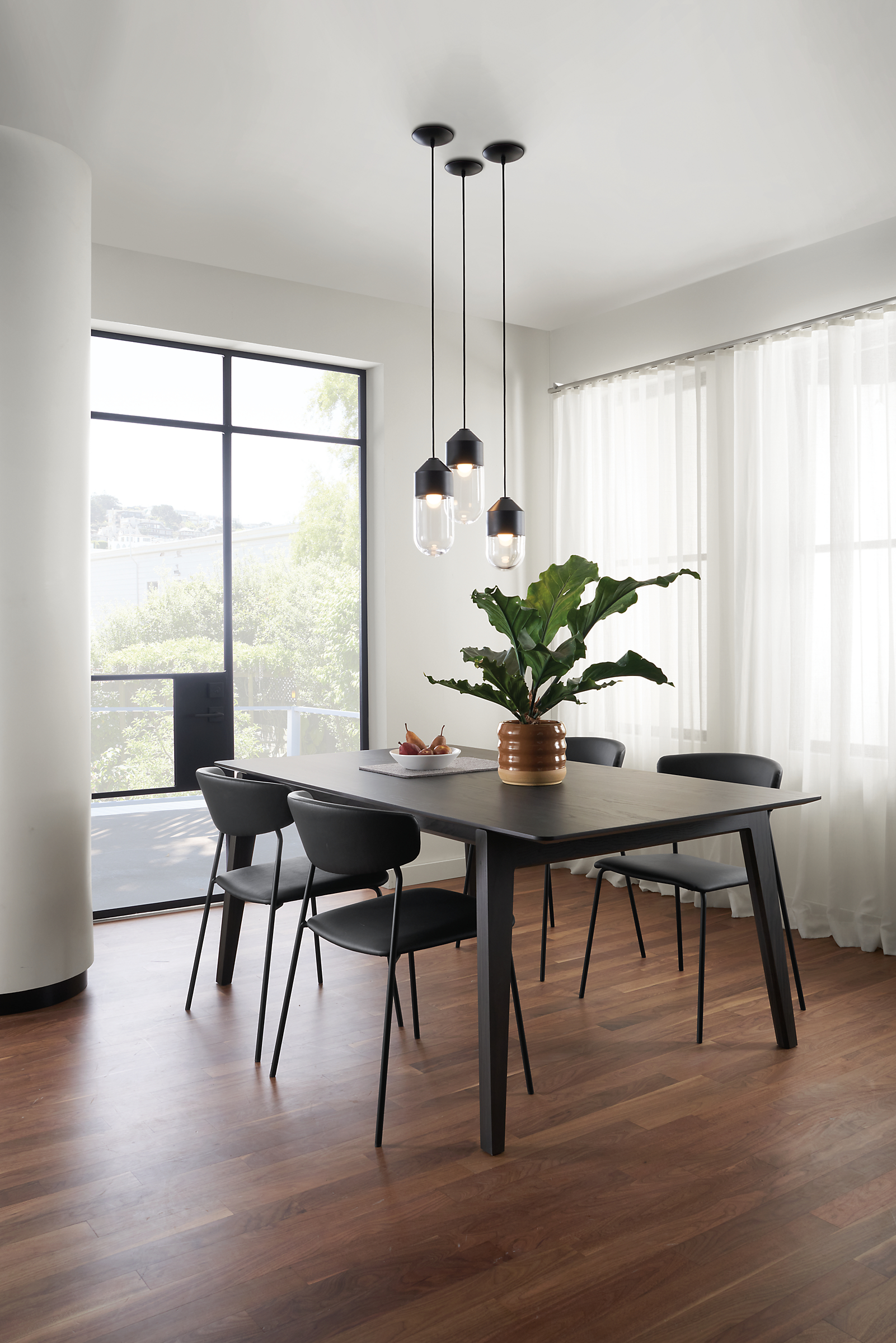 Room setting with an Orlin Dining Table and Wolfgang Chairs with a Ballad pendant grouping.