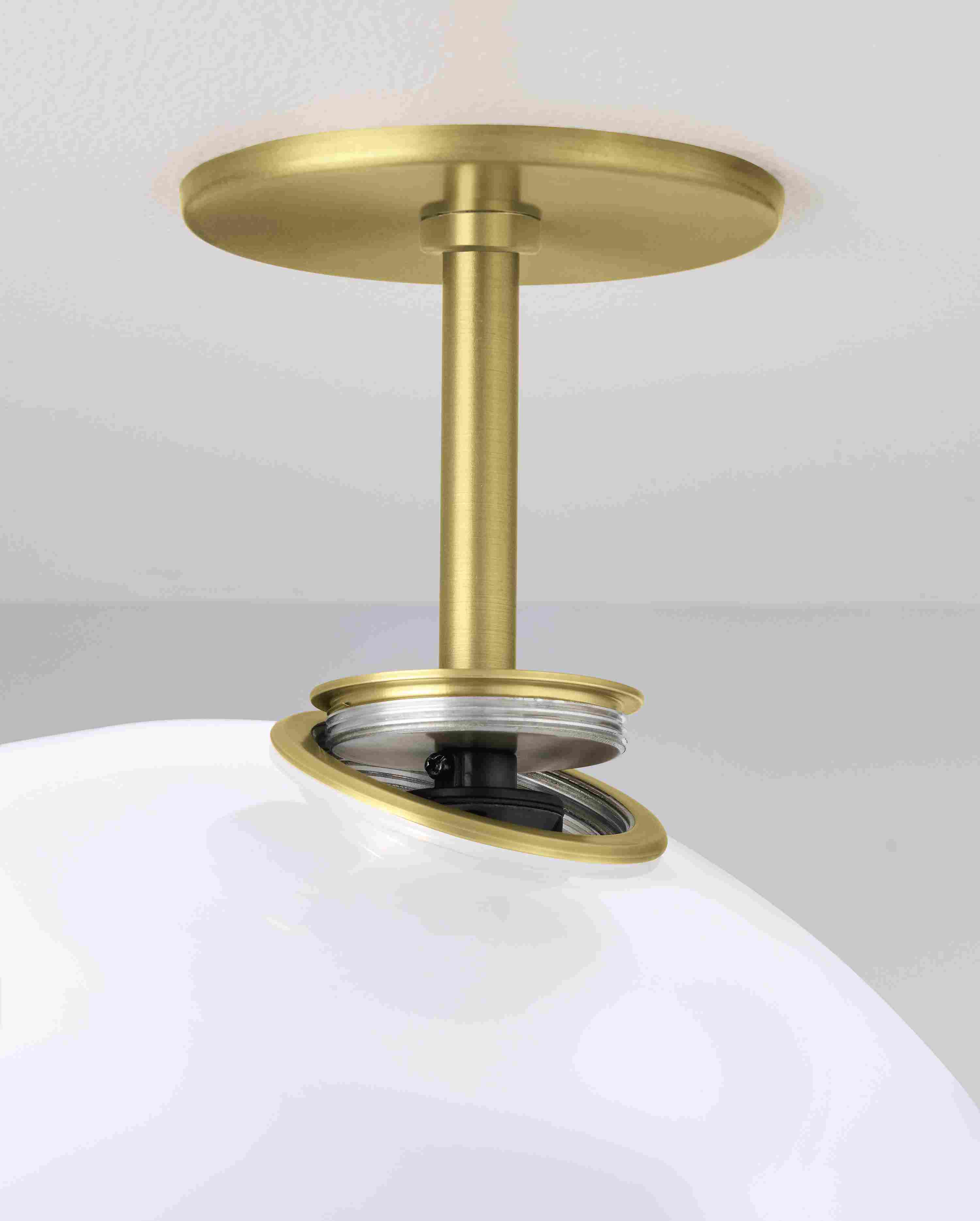 Close up of ceiling plate and screw mount on an Osiris lighting pendant in brushed gold powdercoat and opal glass.