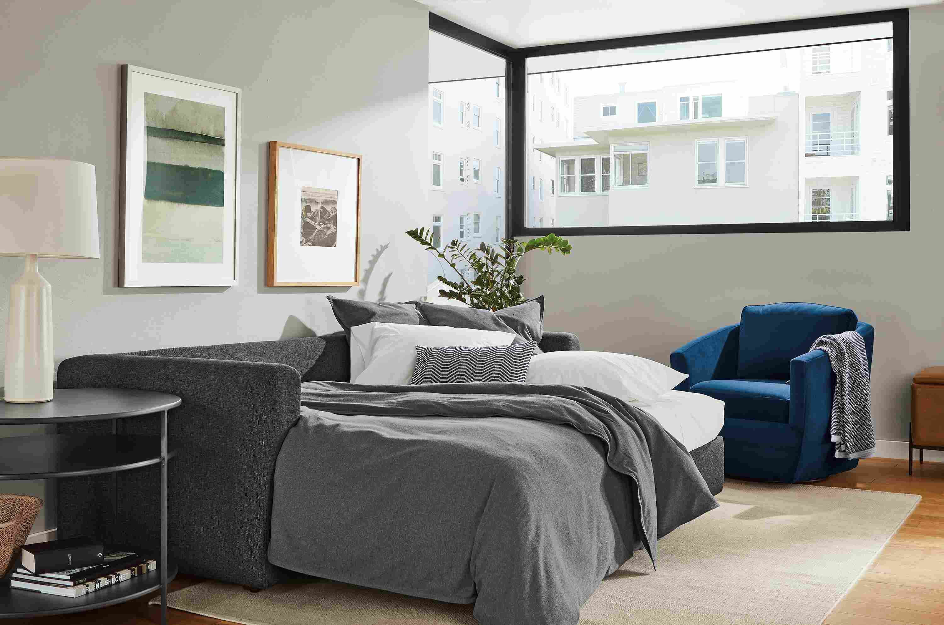 Living room with Oxford sleeper sofa in Sumner Charcoal extended with bedding.