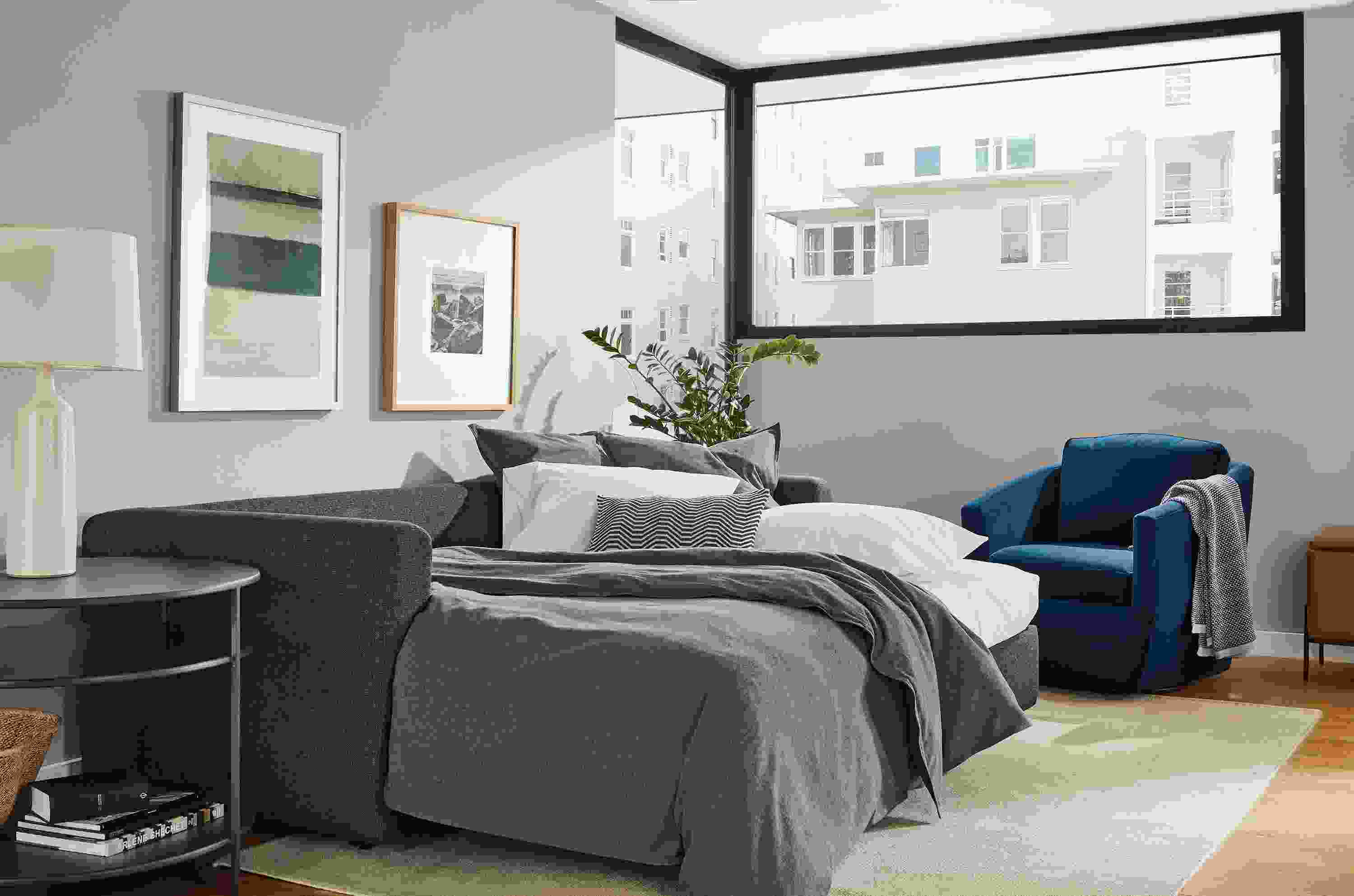 Living room with Oxford sleeper sofa in Sumner Charcoal extended with bedding.