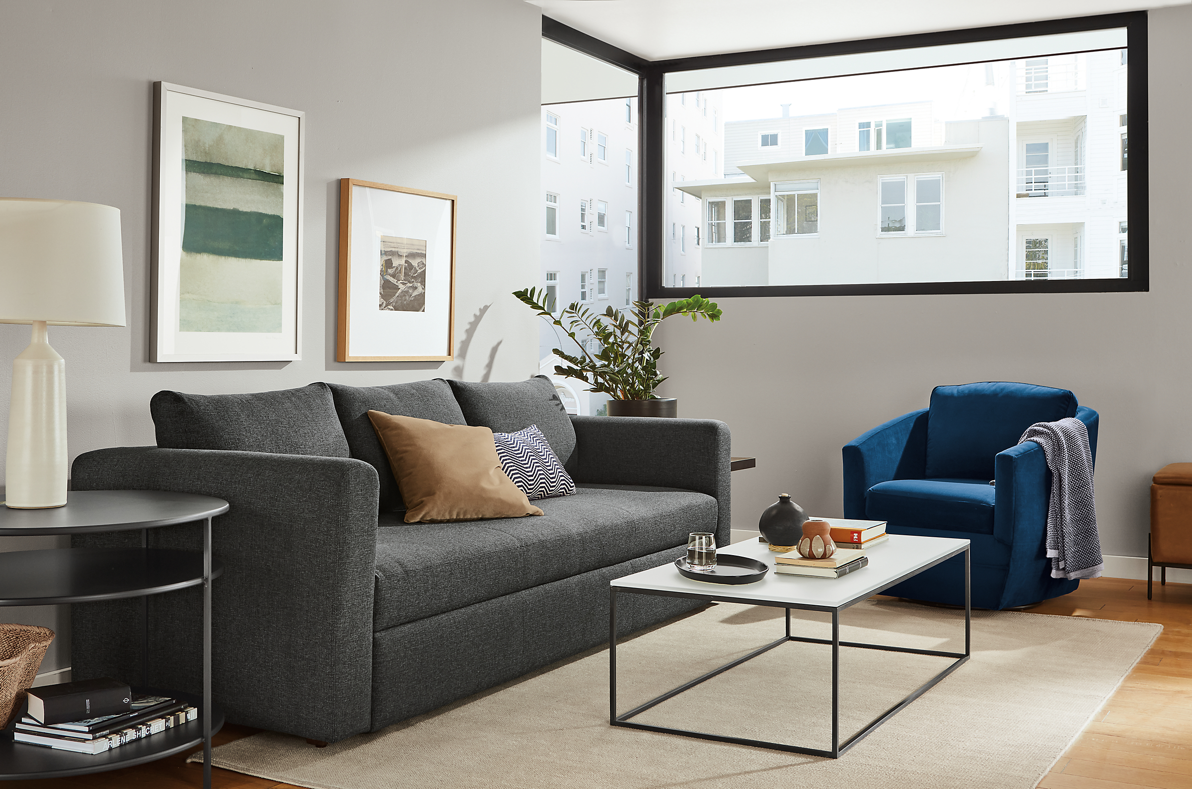 living room with oxford sleeper sofa, otis chair in blue, tyne cofffee table.