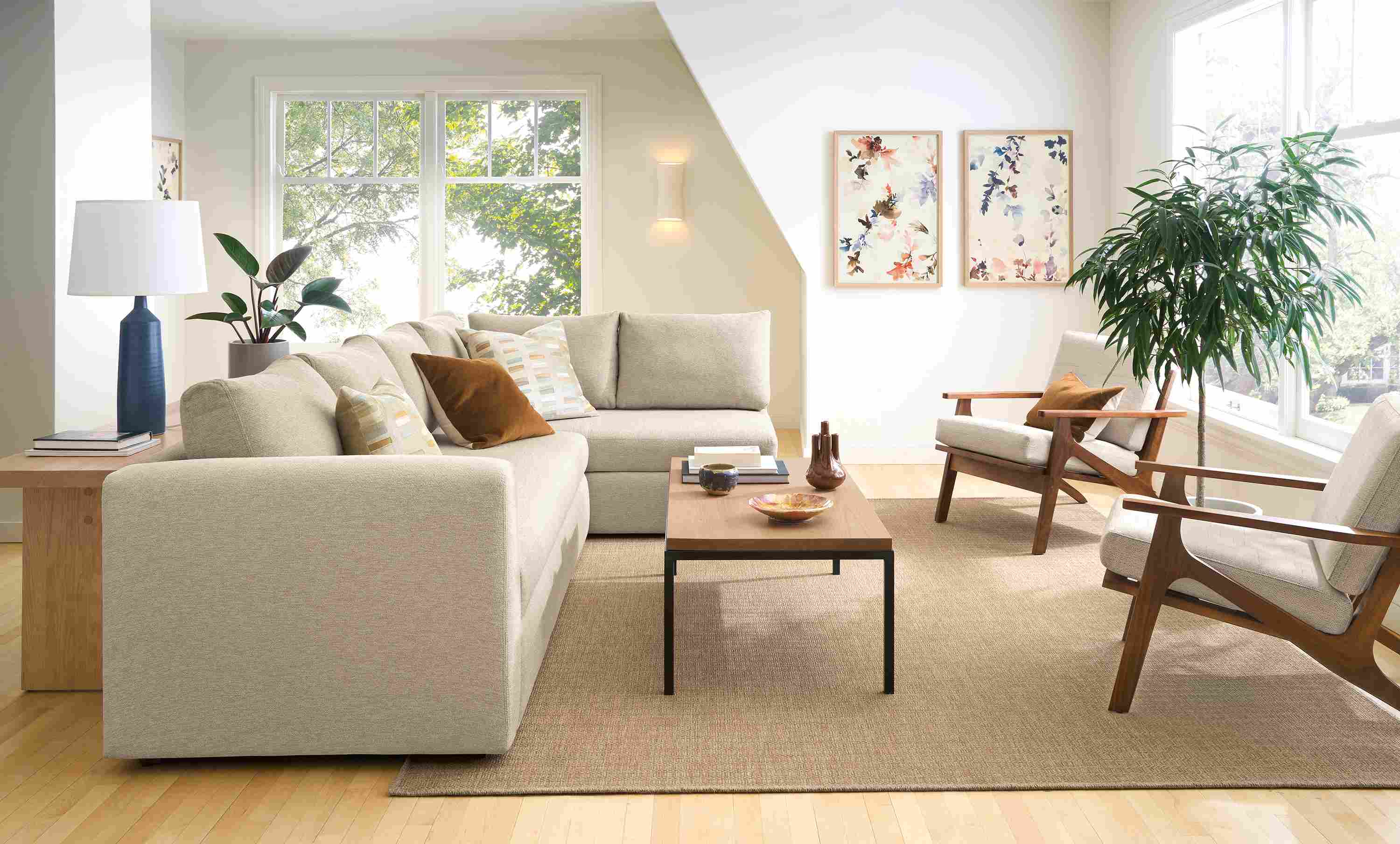 Living room with Oxford track arm 123-wide pop-up platform queen sleeper in tatum oatmeal and Leland 8 by 10 rug in sand.