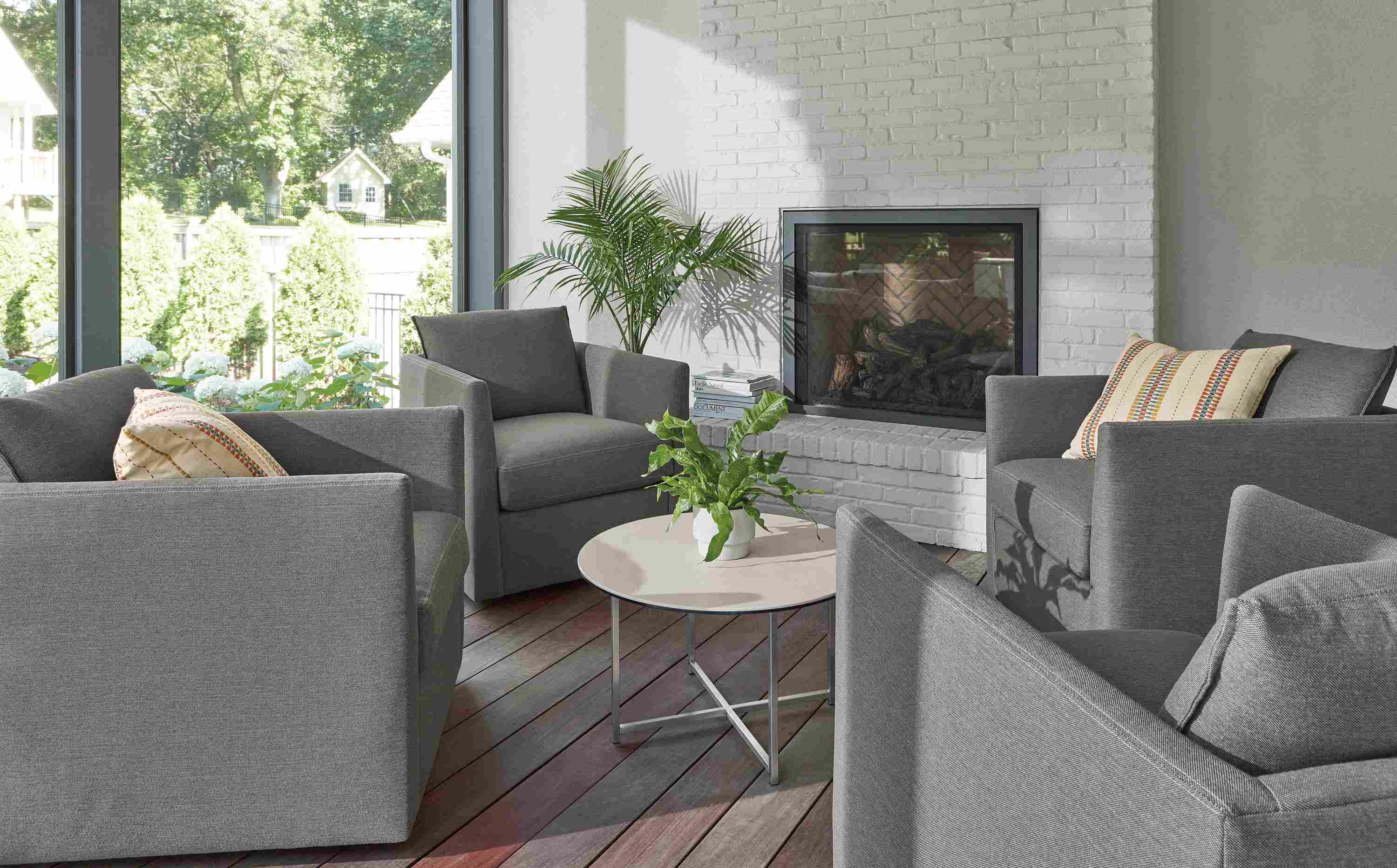 Sunroom with 4 Palm outdoor swivel chairs in Pelham grey with Classic 27-round outdoor coffee table.