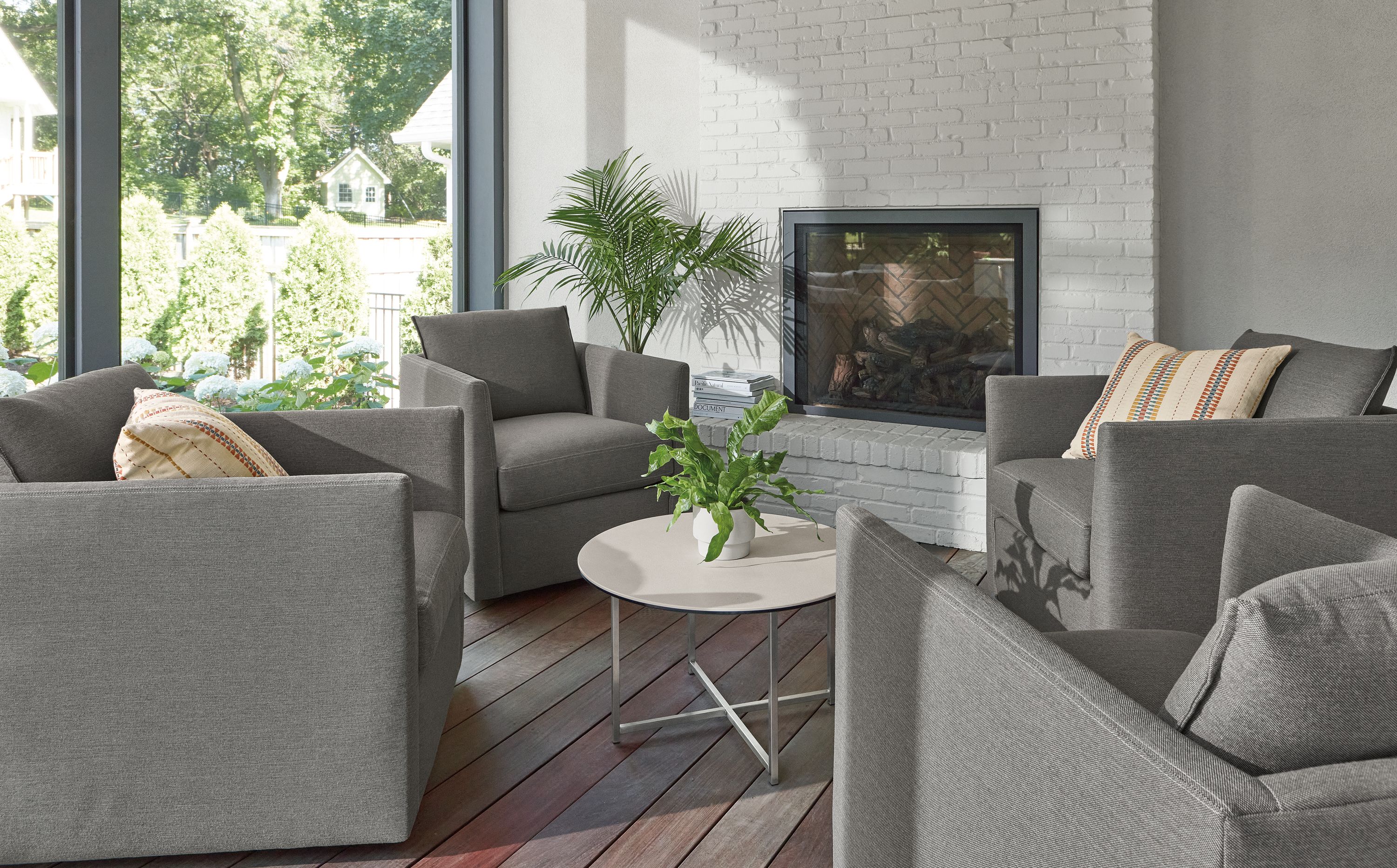 Sunroom with 4 Palm outdoor swivel chairs in Pelham grey with Classic 27-round outdoor coffee table.