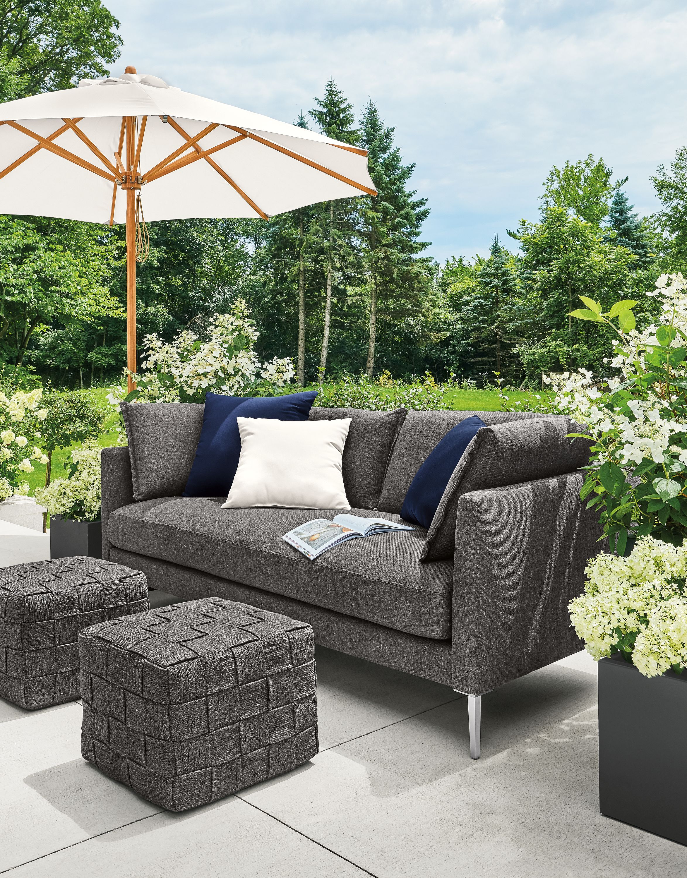 Detail of Palm sofa and Flet ottomans on patio with Cirro umbrella.