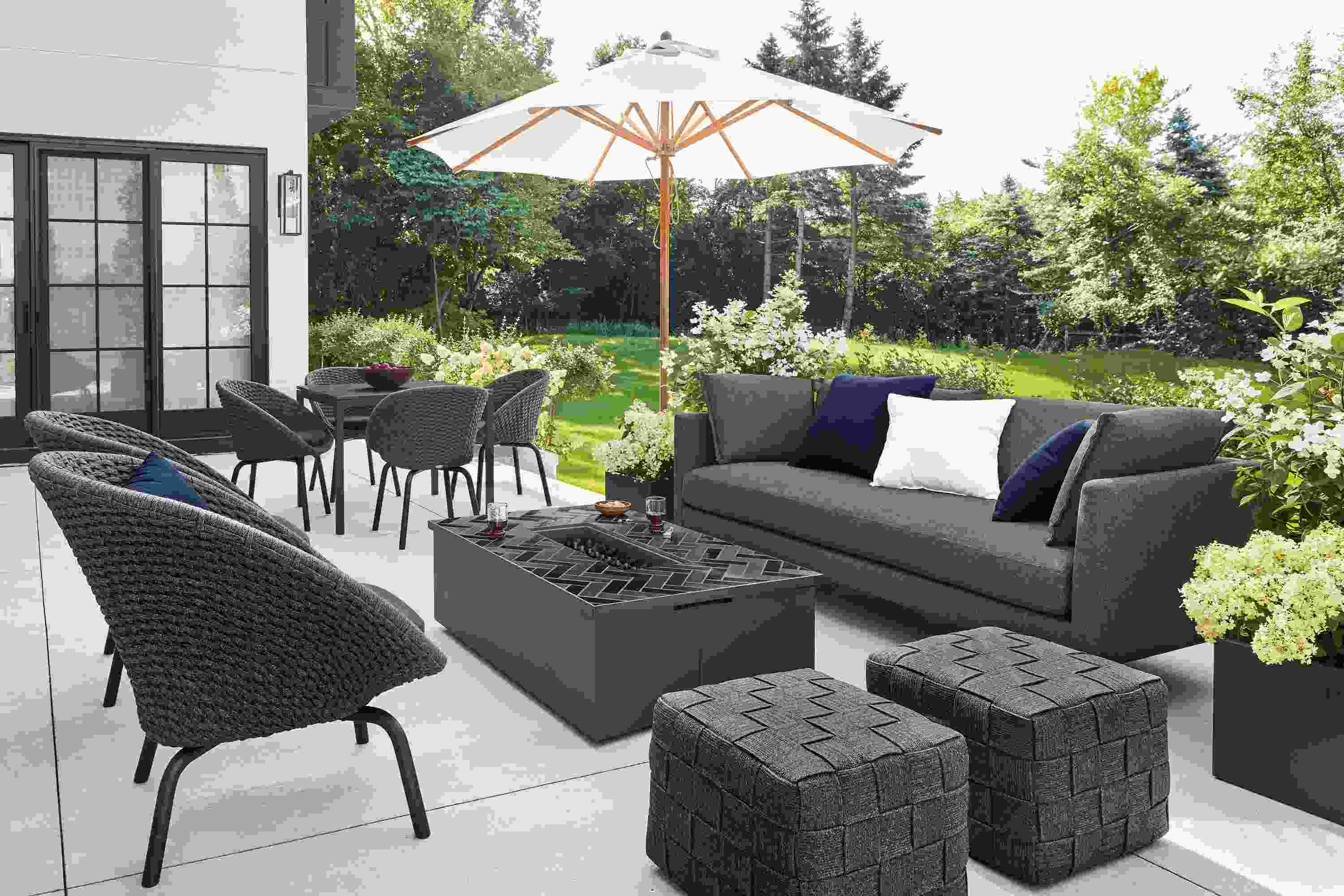 Detail of Palm sofa with Flet lounge chairs and Flet ottomans and Adara tile top fire table on patio.