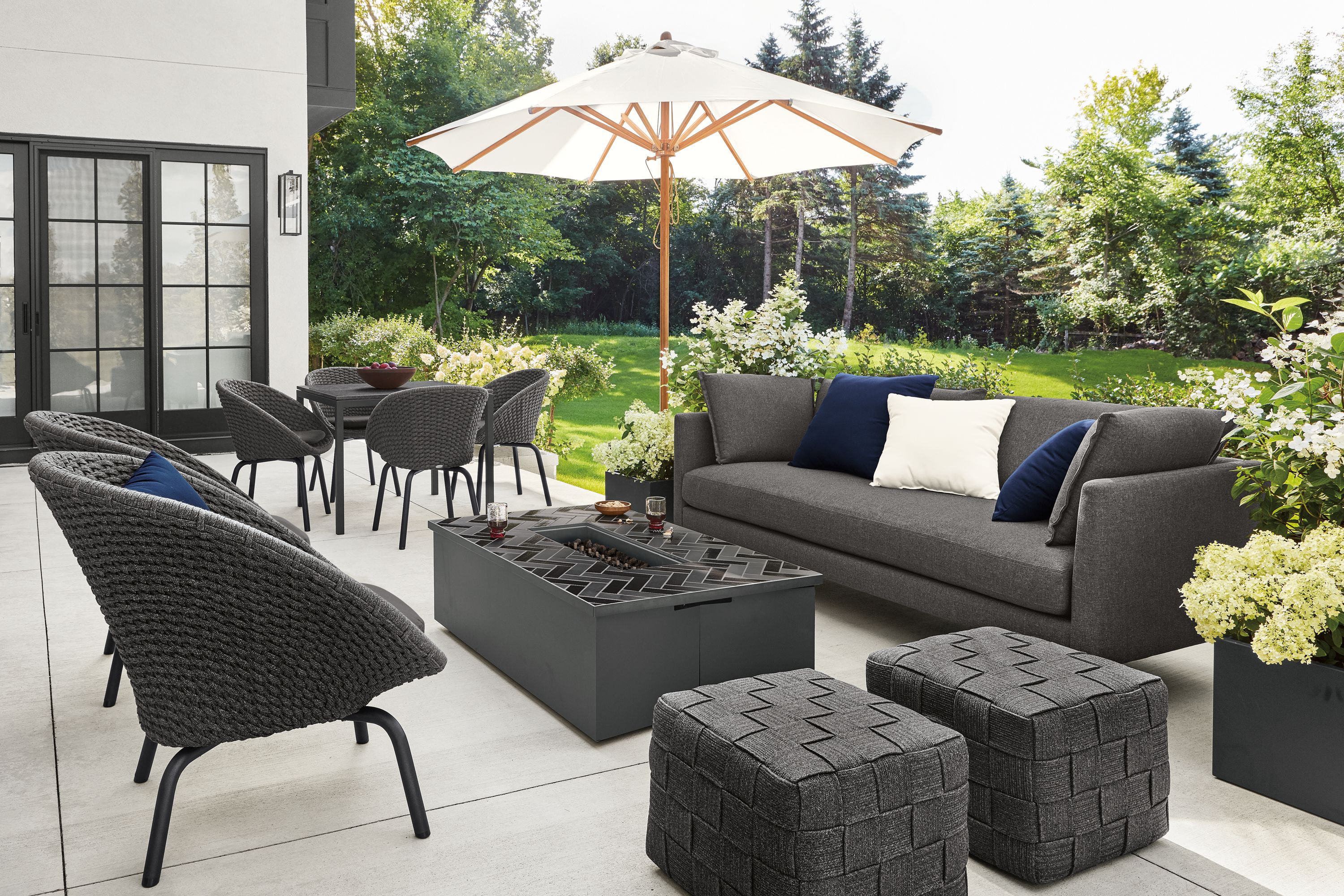 Detail of Palm sofa with Flet lounge chairs and Flet ottomans and Adara tile top fire table on patio.
