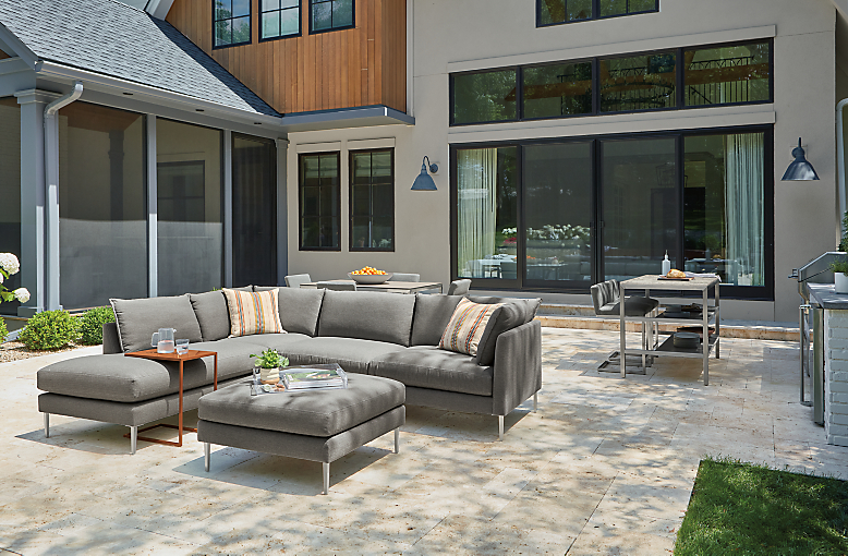 Palm sectional and ottoman in Pelham grey, Parsons 60-wide outdoor counter with two narrow shelves and Finn counter stools.