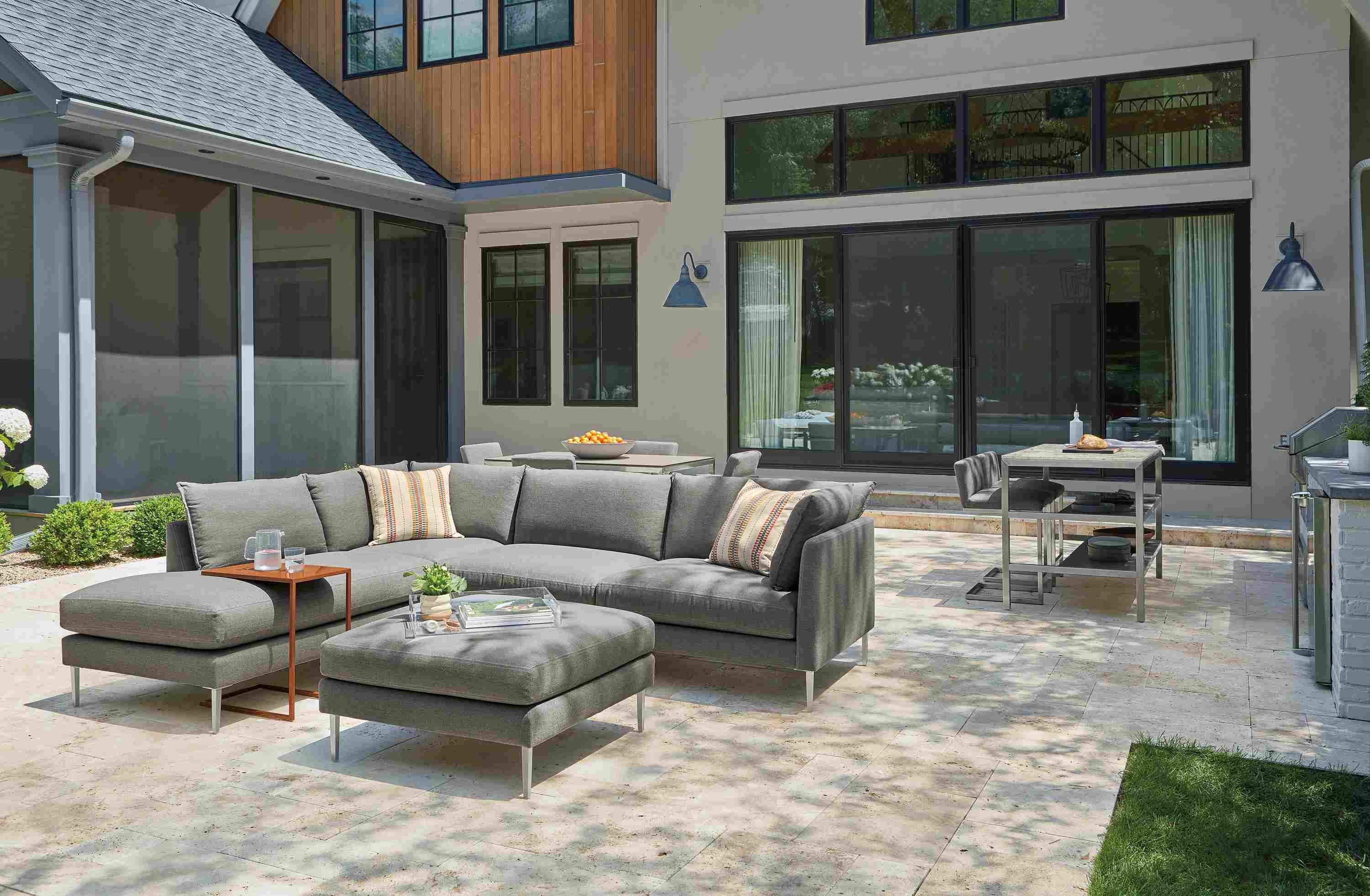 Palm sectional and ottoman in Pelham grey, Parsons 60-wide outdoor counter with 2 narrow shelves and Finn counter stools.