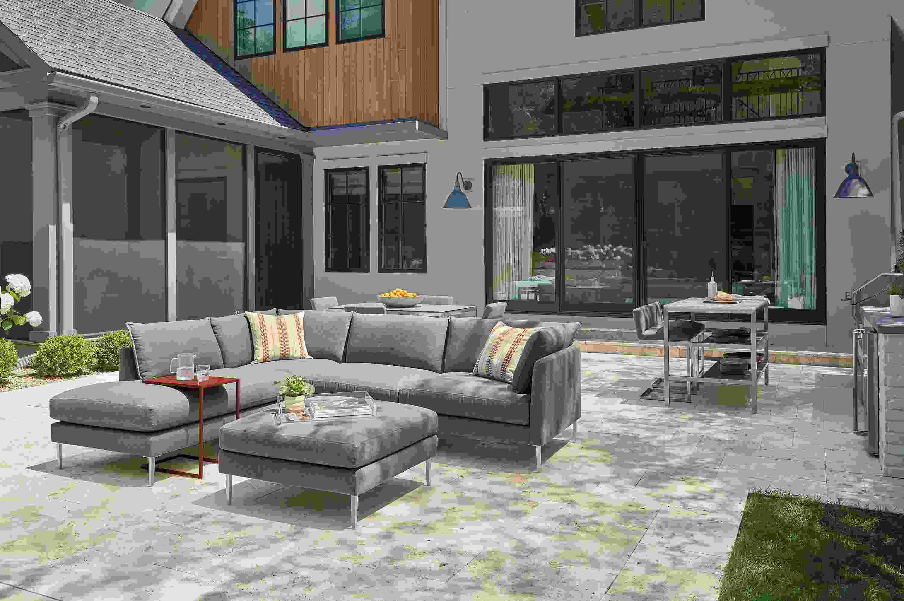 Palm sectional and ottoman in Pelham grey, Parsons 60-wide outdoor counter with two narrow shelves and Finn counter stools.