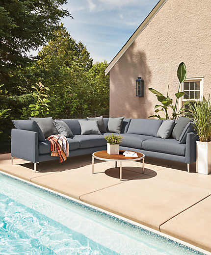 Patio setting with a Palm Three-Piece Sectional, Montego Round Coffee Table and Hue Outdoor Pillows.  