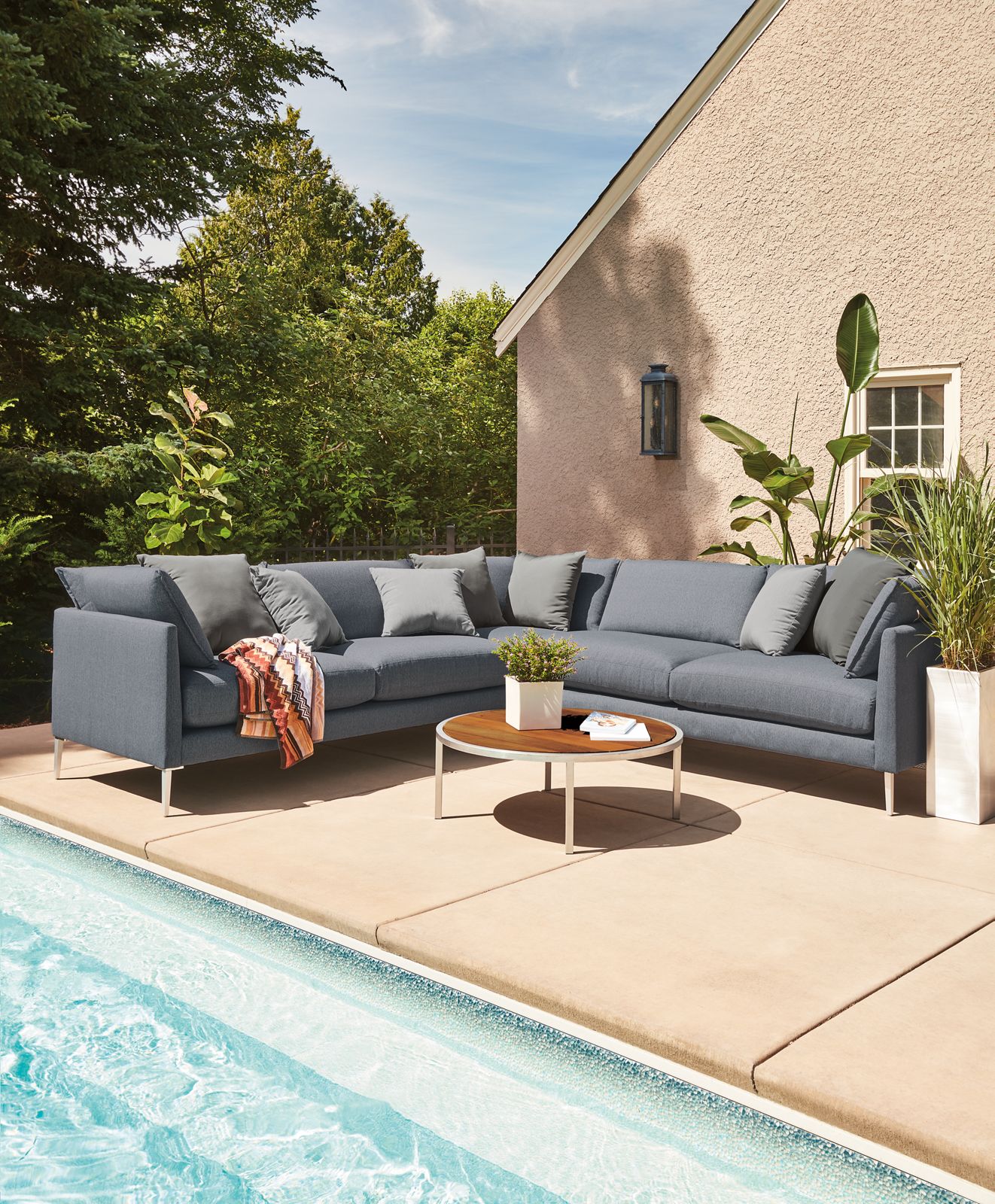 Patio setting with a Palm Three-Piece Sectional, Montego Round Coffee Table and Hue Outdoor Pillows.