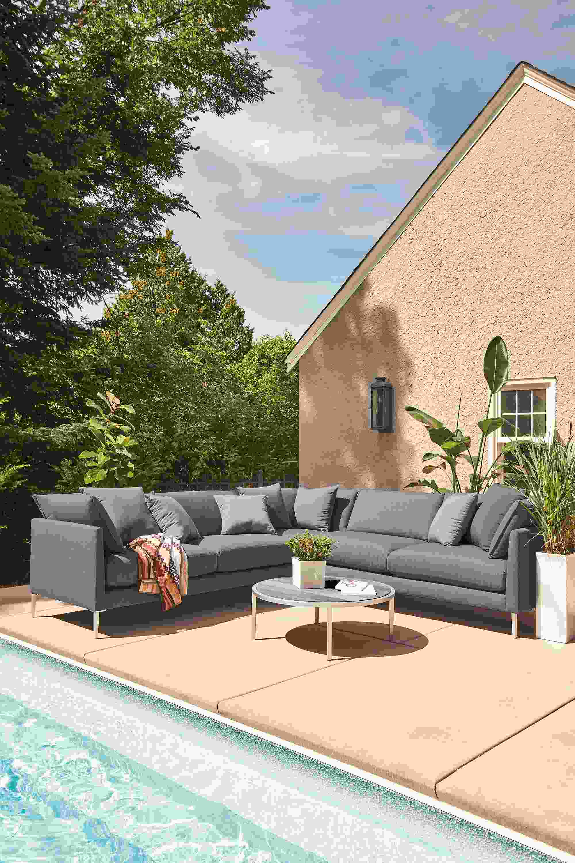 Poolside area with Palm 3-piece sectional in Mist Navy and Montego round coffee table in aged reclaimed ash.