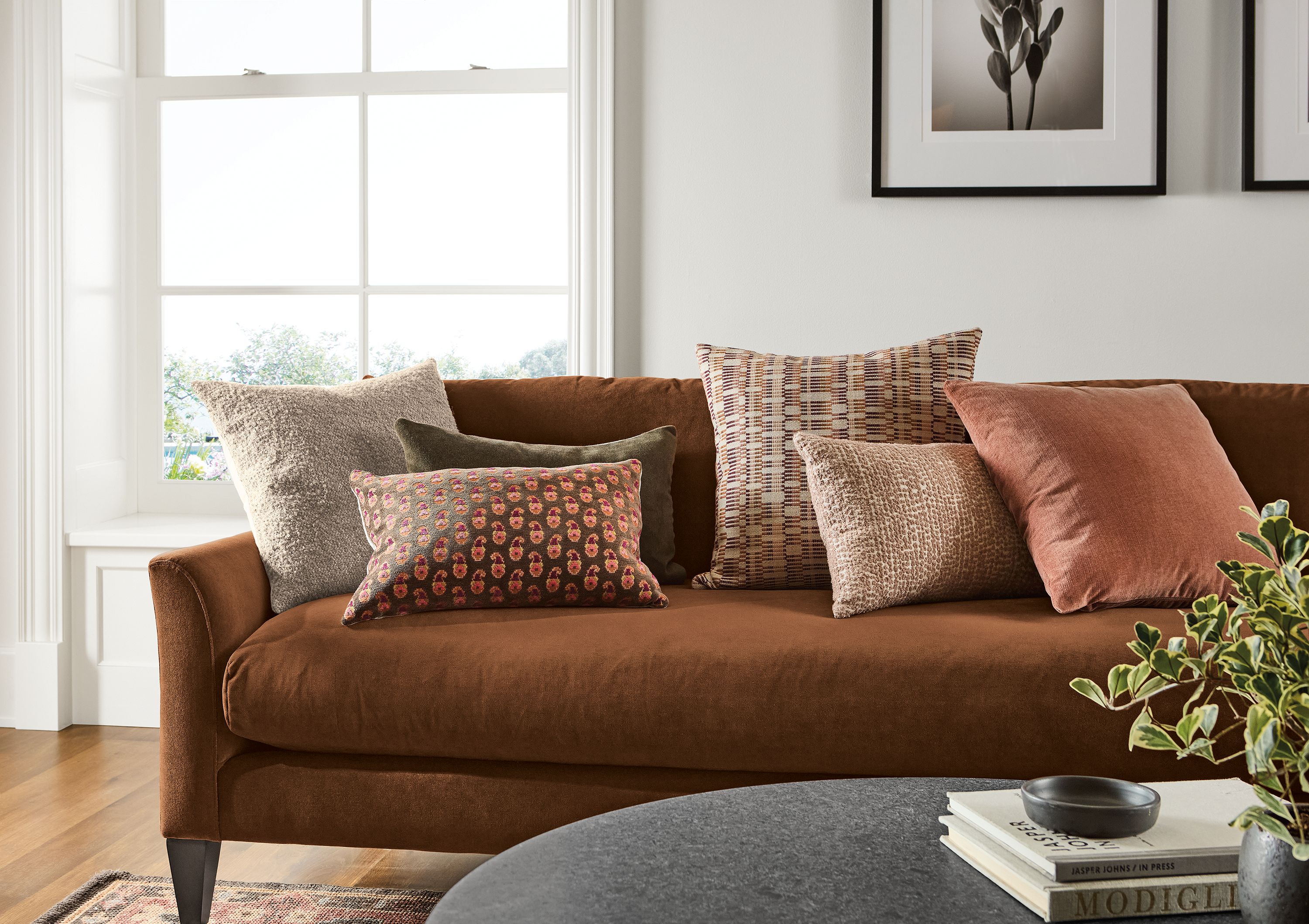 Living room with multiple pillows on a sybil sofa including palmer in taupe, greer in umber, wool velvet in mink and koko in opal.