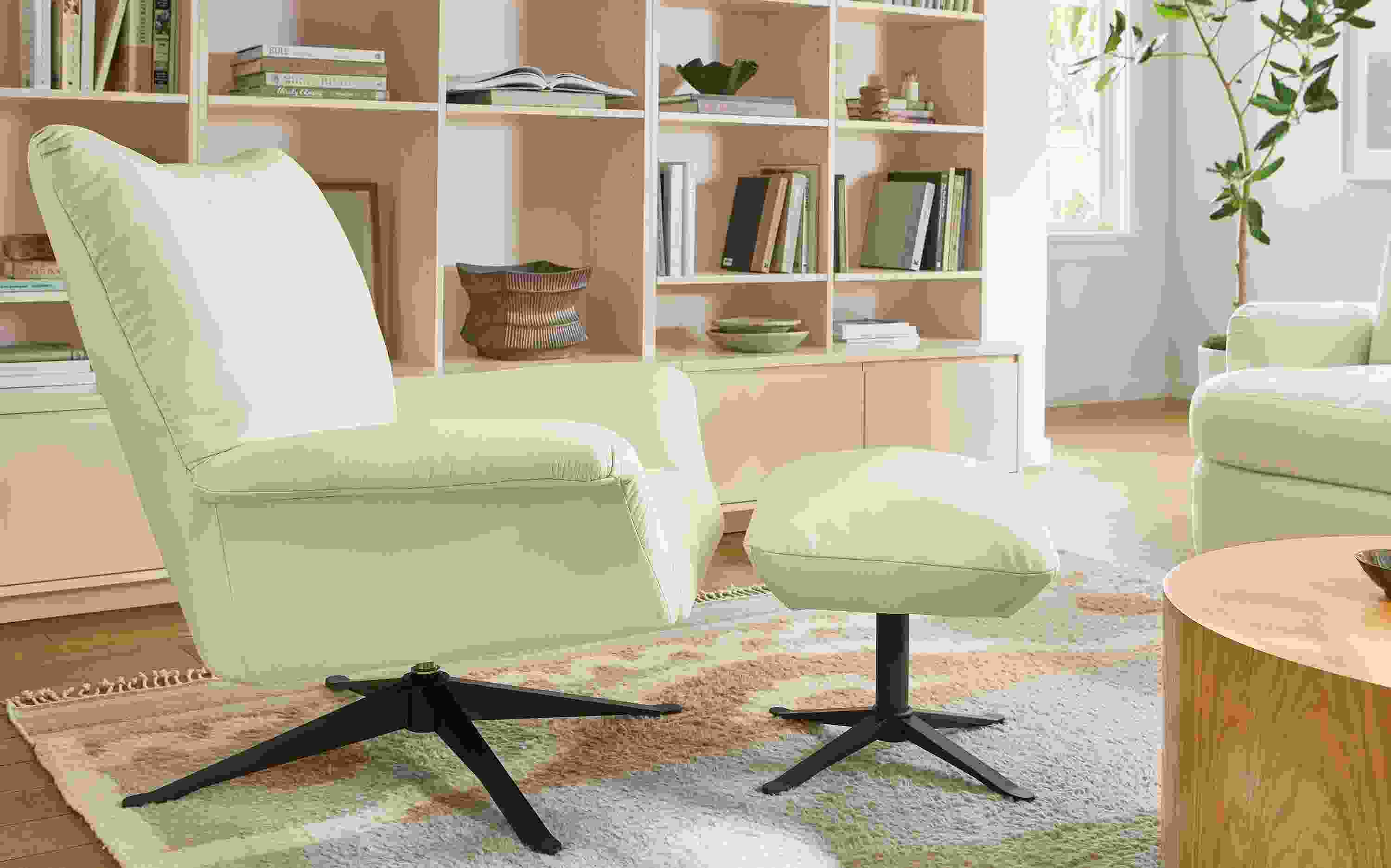 Living room with Paris swivel chair and ottoman in pesaro ivory and tova rug in sand.