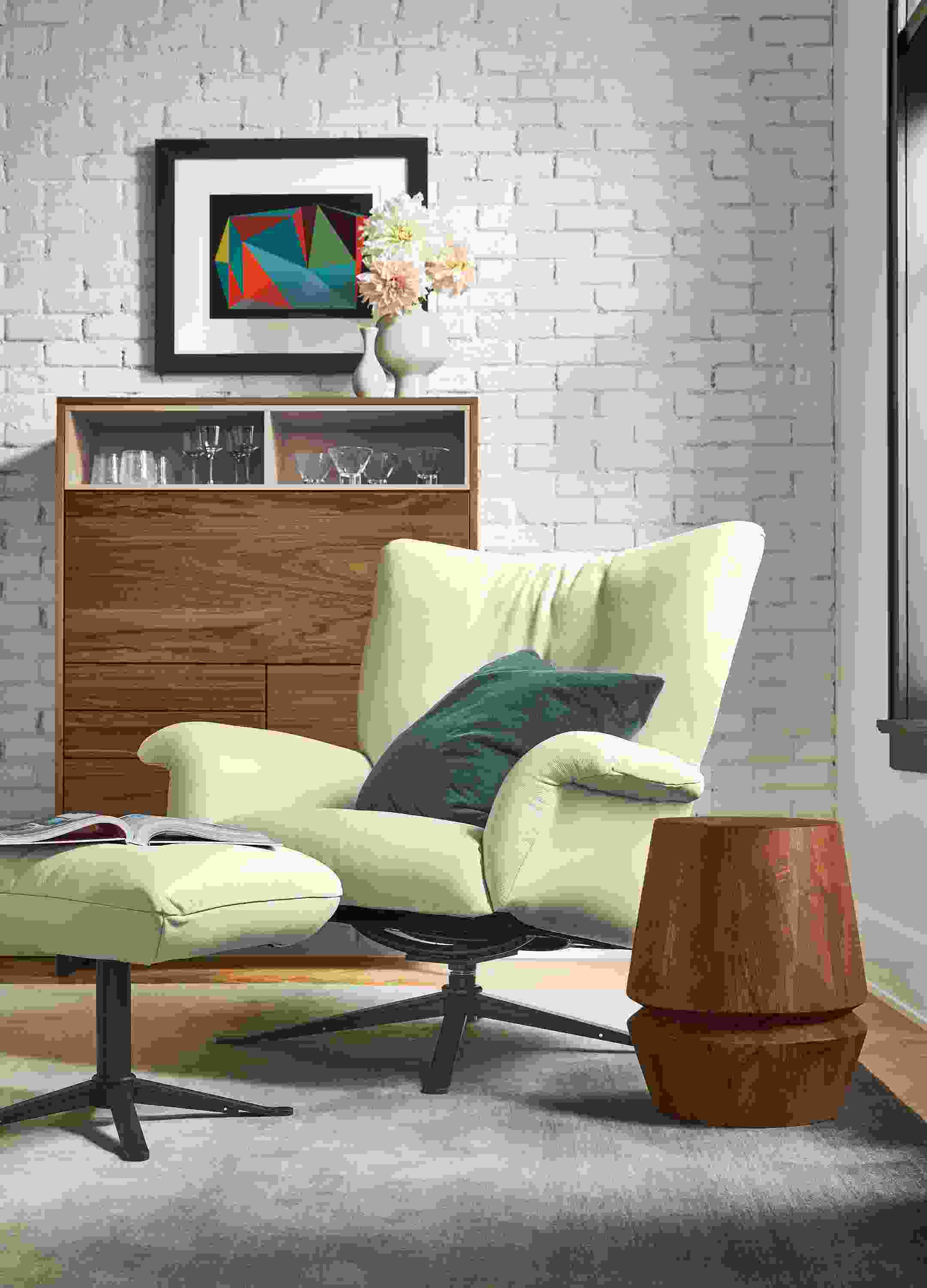 Living area with Paris swivel chair and ottoman in Pesaro Ivory leather and Mosby Armoire in Walnut.