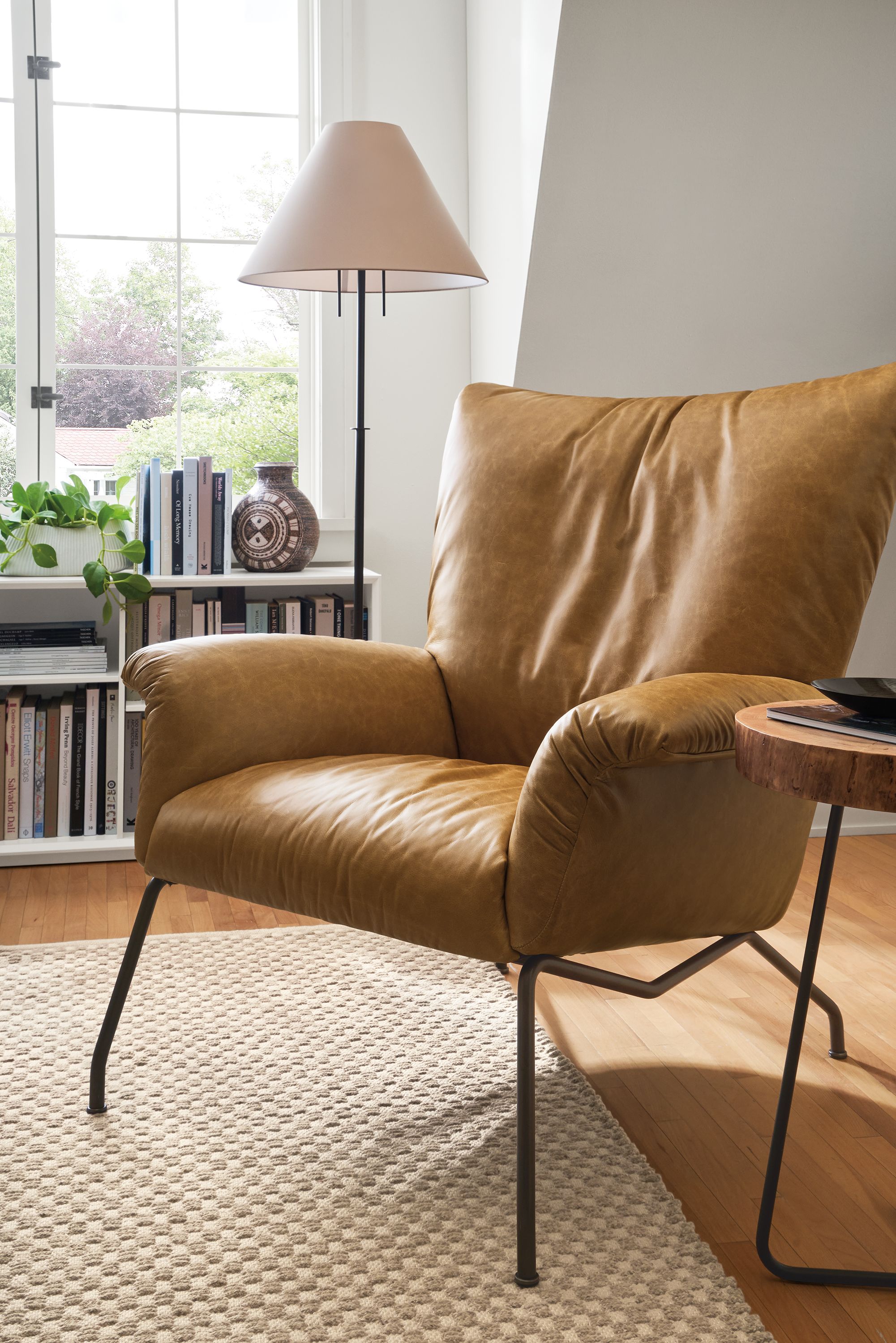 living room with paris chair in palermo camel leather, weldon rug in sand and lucille floor lamp.