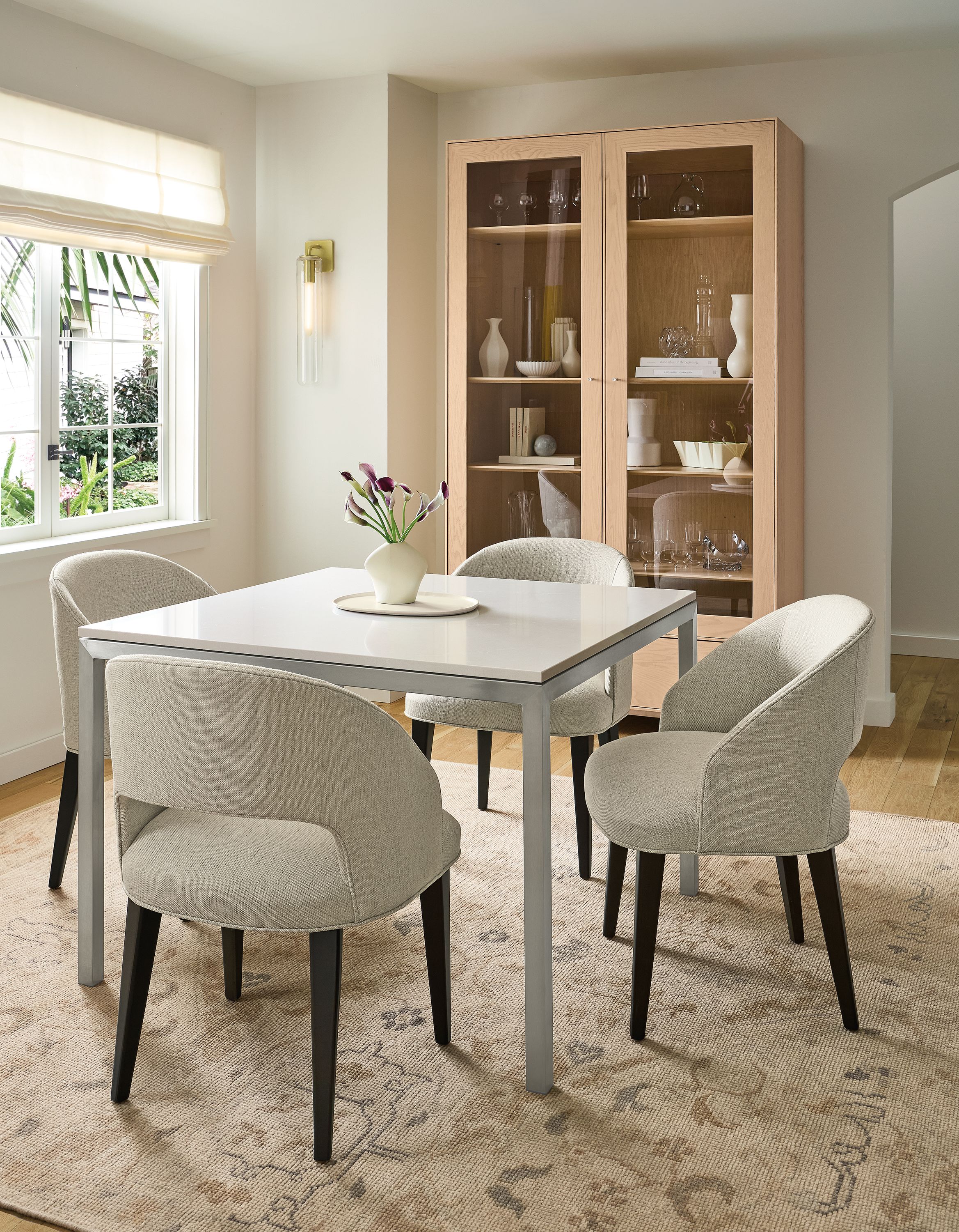 Dining room with Parsons 40-wide table in stainless with Light Grey Quartz top and 4 Esme chairs in Sumner Linen.