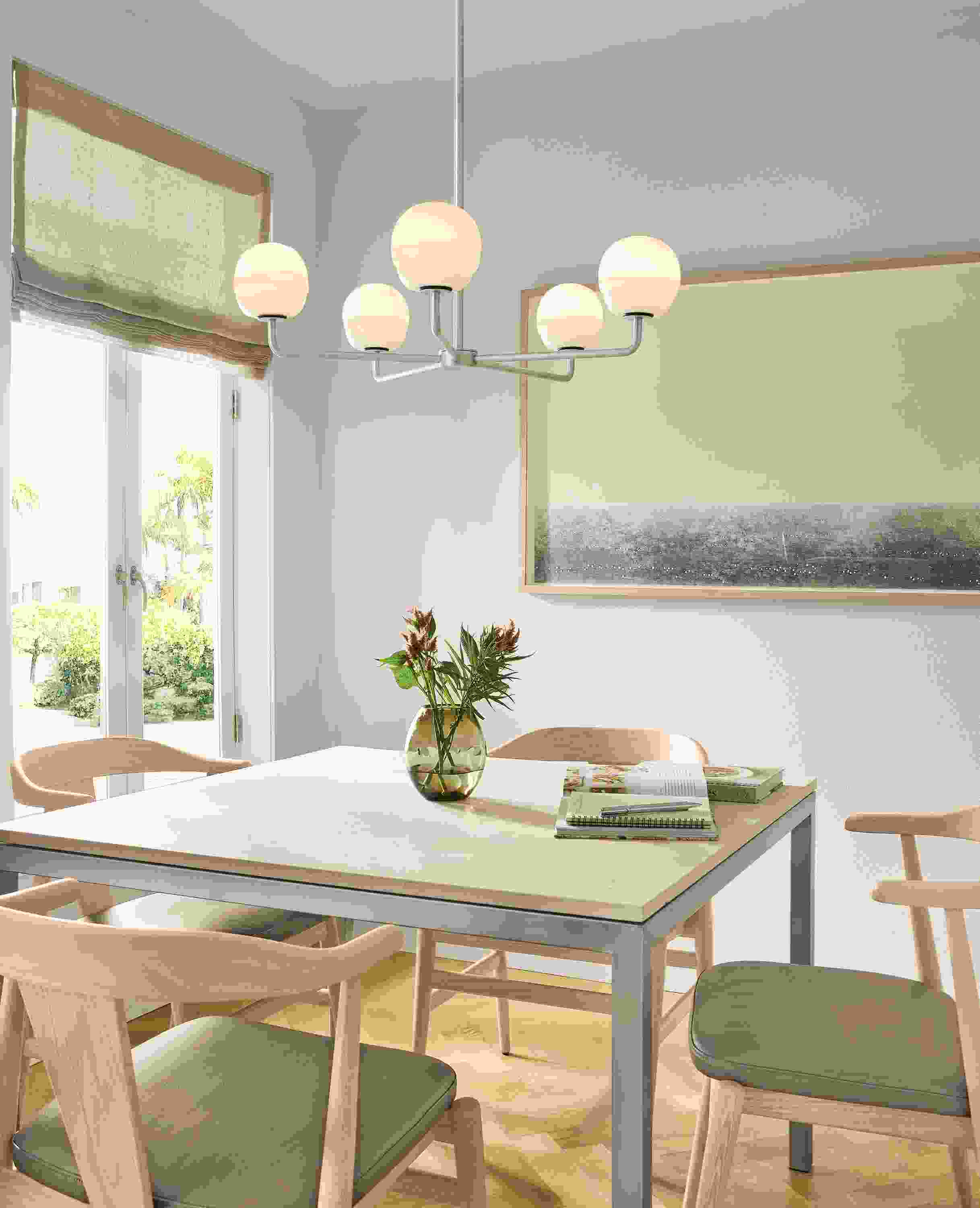 Dining area with Parson table in marbled beige stone and stainless and 4 Evan arm chairs in Pesaro Putty leather.