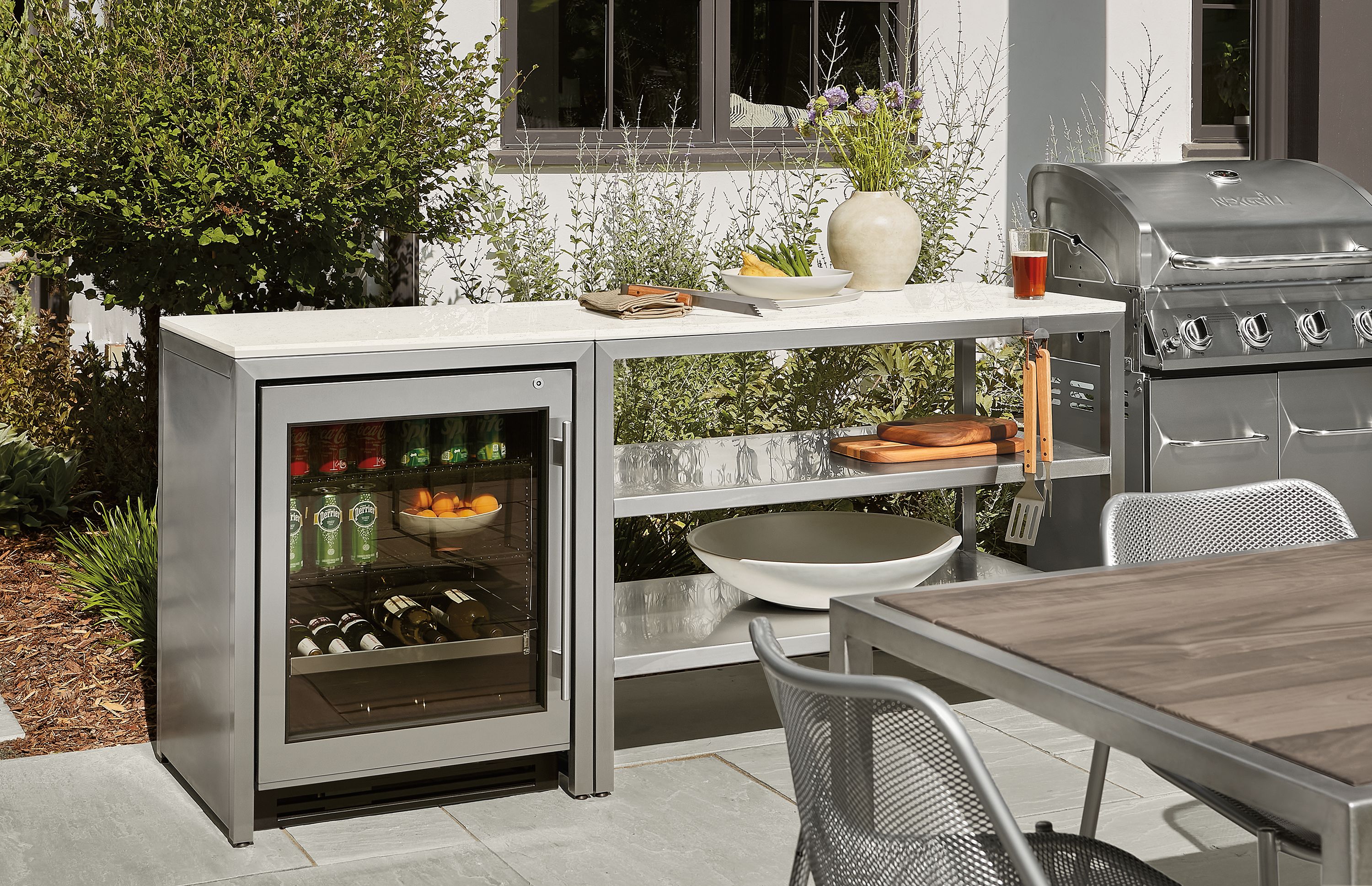 Outdoor space with parsons modular outdoor kitchen with fridge and montego in aged thermally modified oak.