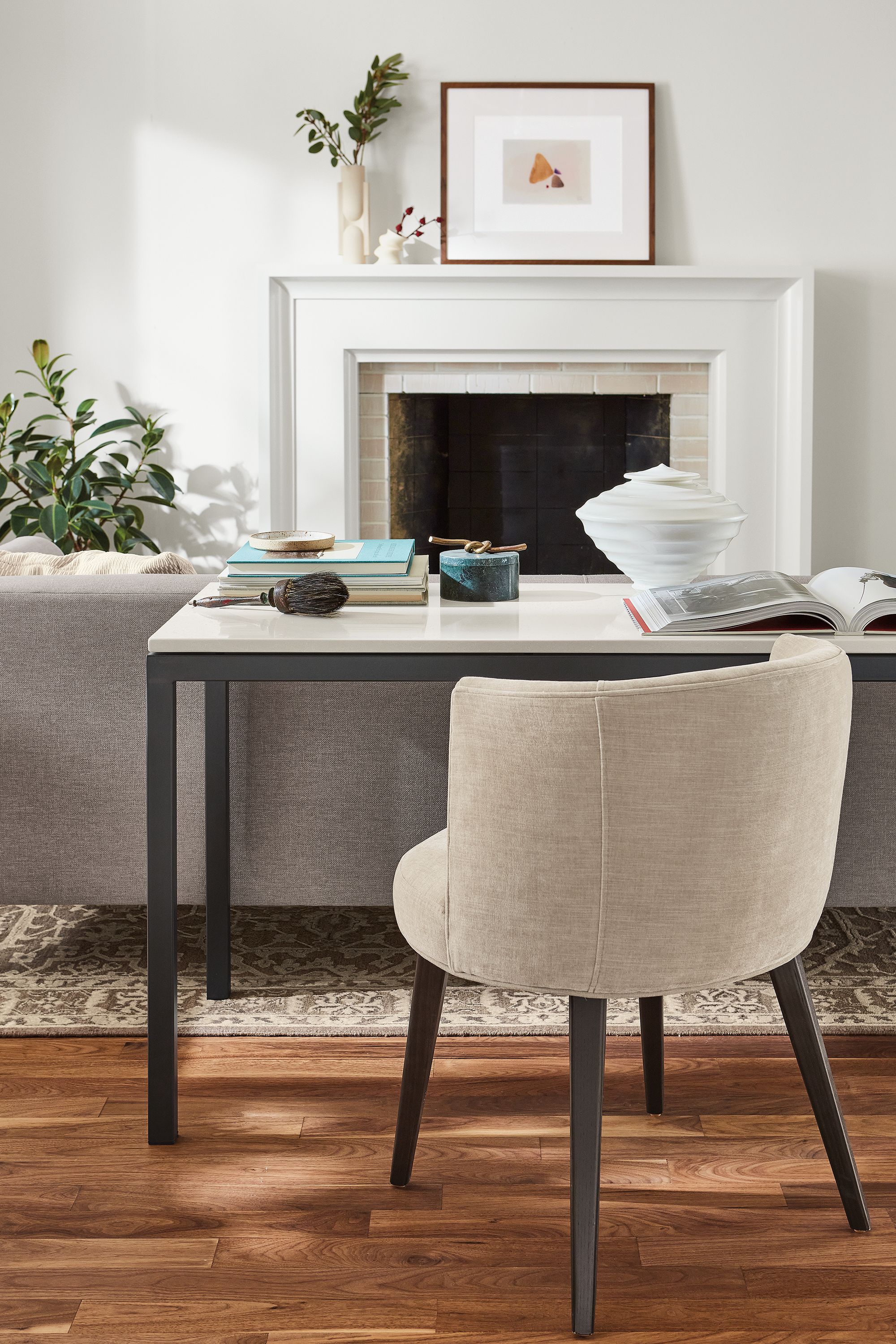 Living room setting with Parsons 60-wide table in natural steel with light grey quartz top and June side chair in Mori oatmeal.