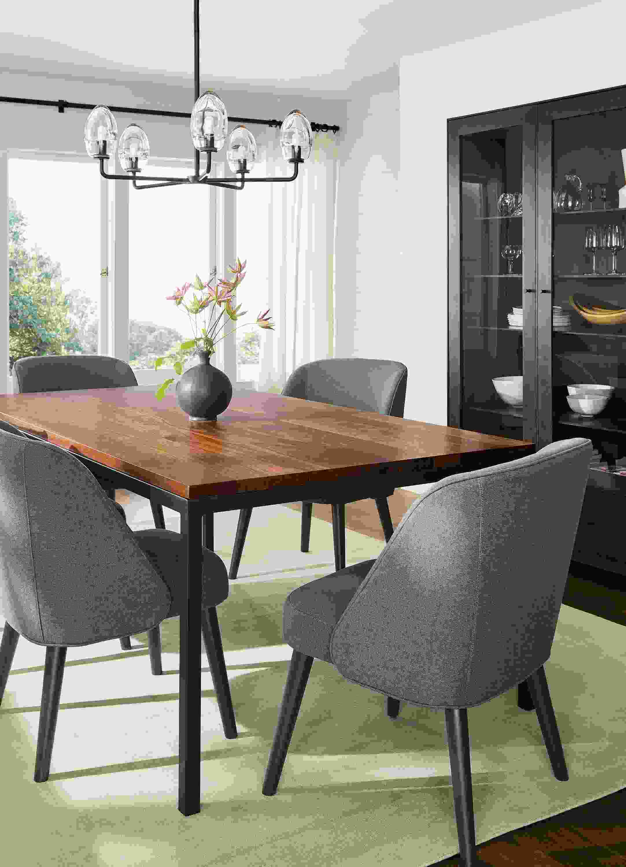 Dining room with parsons table in walnut and natural steel and 4 cora side chairs in myers pine with charcoal legs and luco rug in silver.