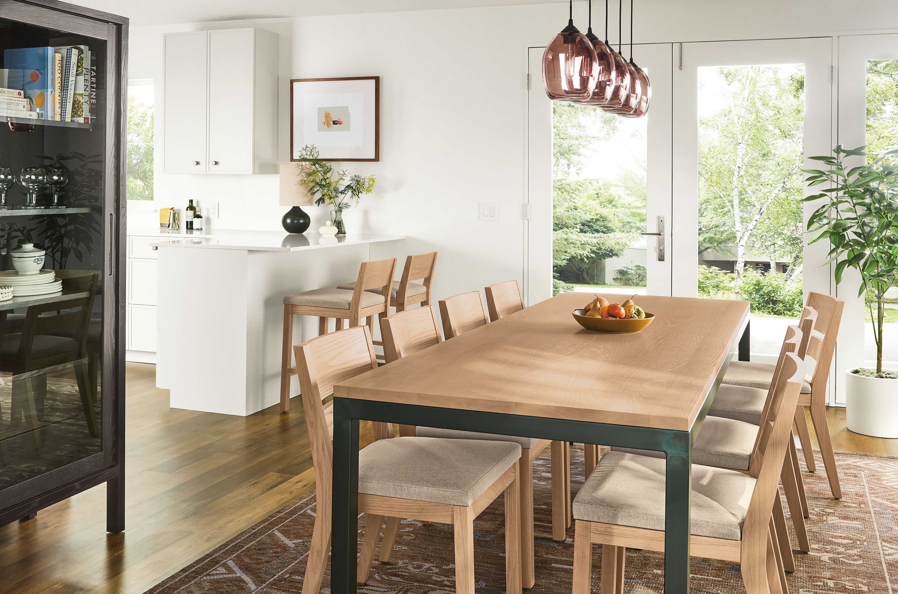 Dining room with Parsons 96-wide table in rye on red oak and natural steel and 8 Afton side chairs in Myers Taupe.
