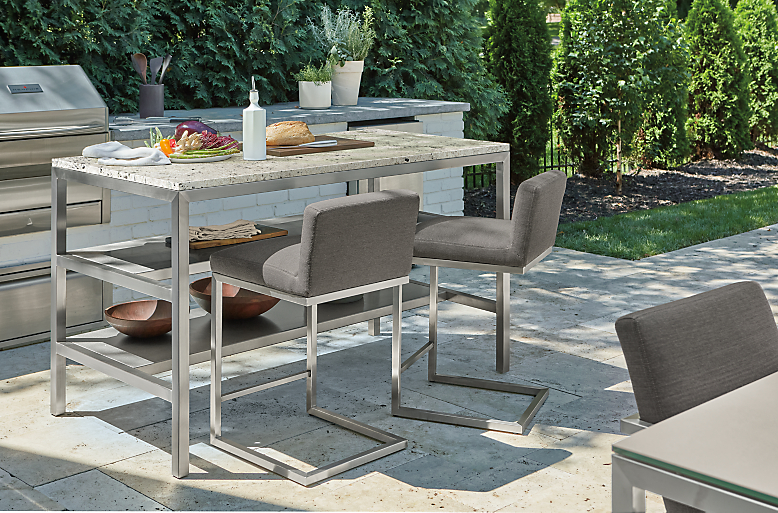 Parsons 60-wide outdoor counter table with two-narrow shelves and two Finn counter stools in Pelham grey.
