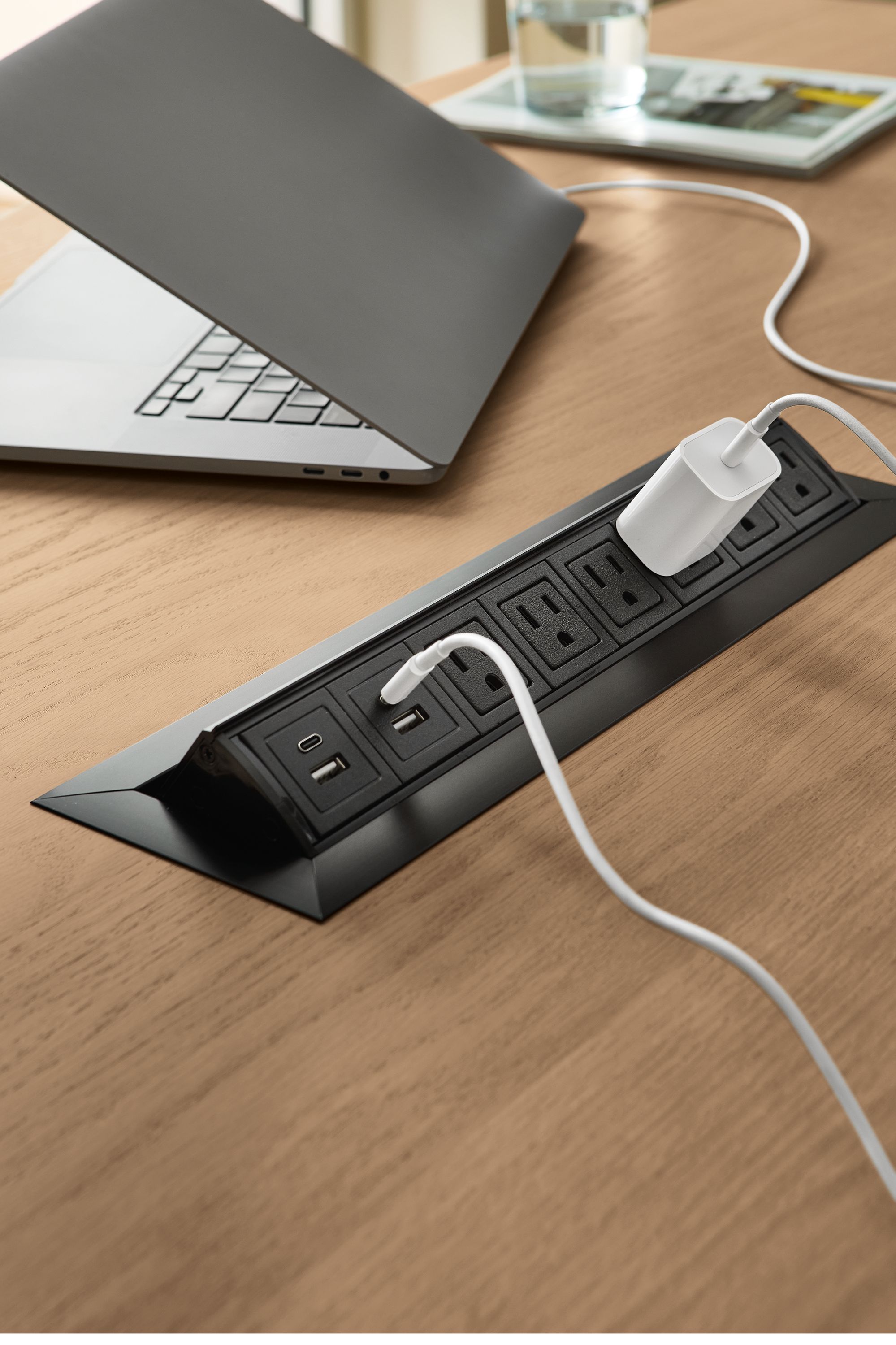 Detail of the 8-port power/charging outlet on a parsons table in rye on red oak and natural steel.