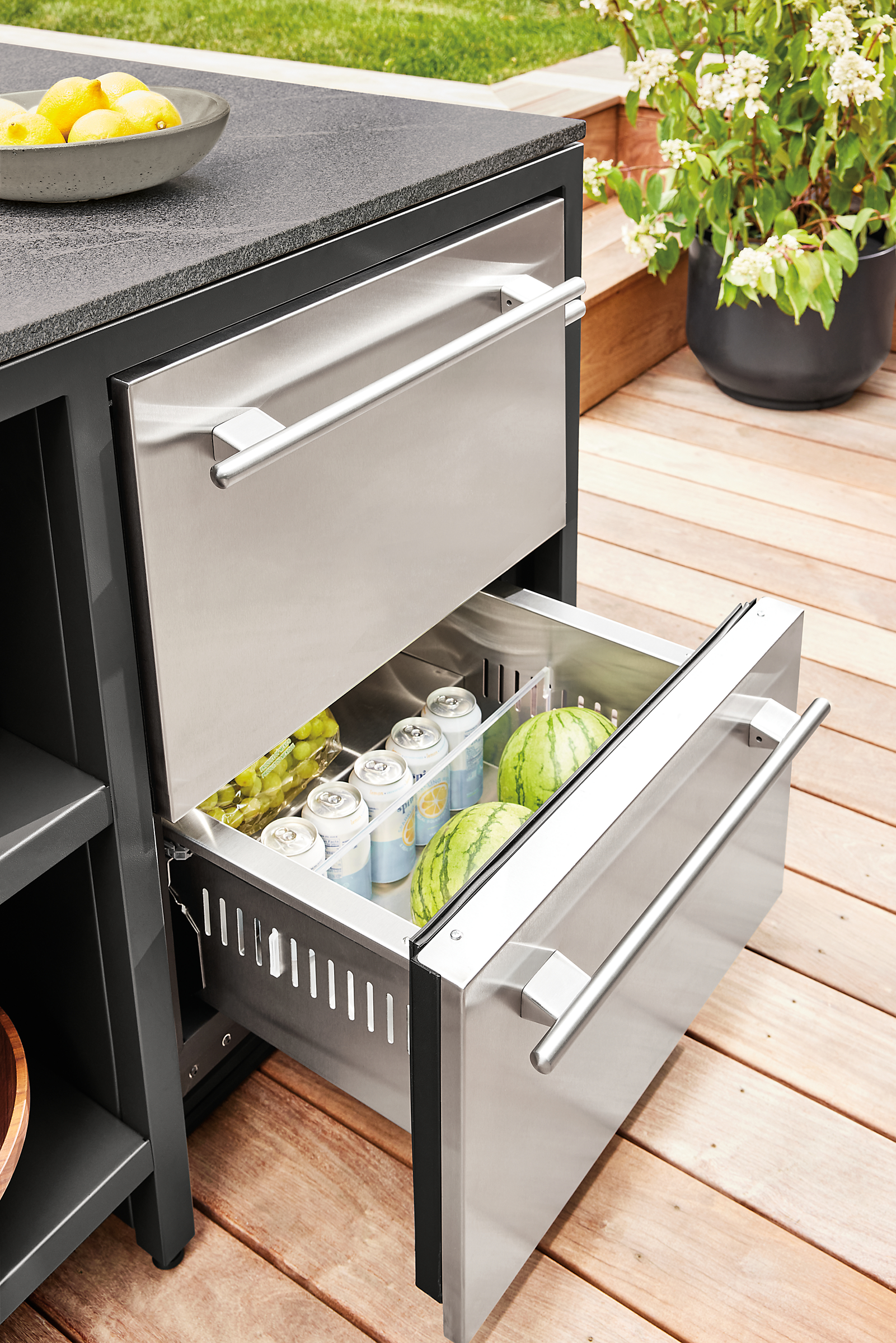 detail of outdoor fridge with 1 drawer open in parsons counter table in outdoor space.