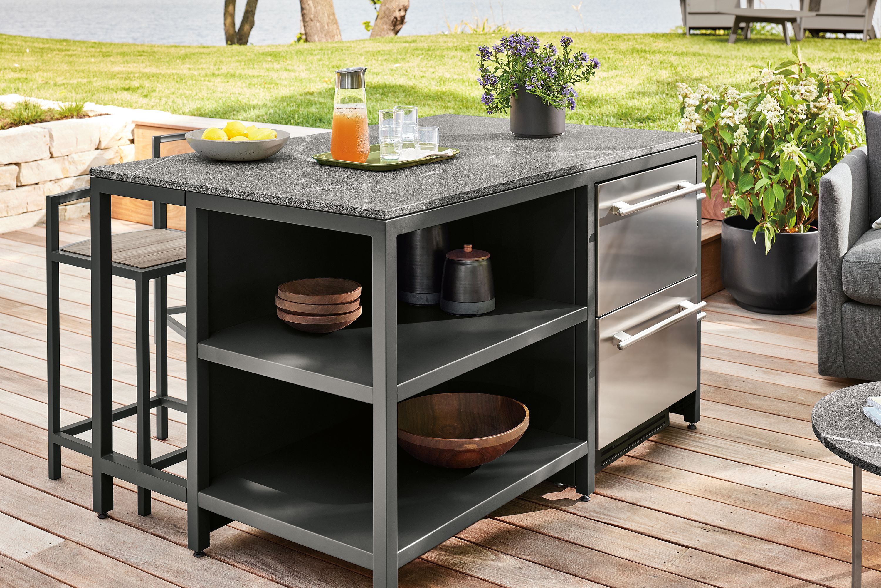 Outdoor space with parsons outdoor counter table with drawer fridge in graphite and elegant grey granite.