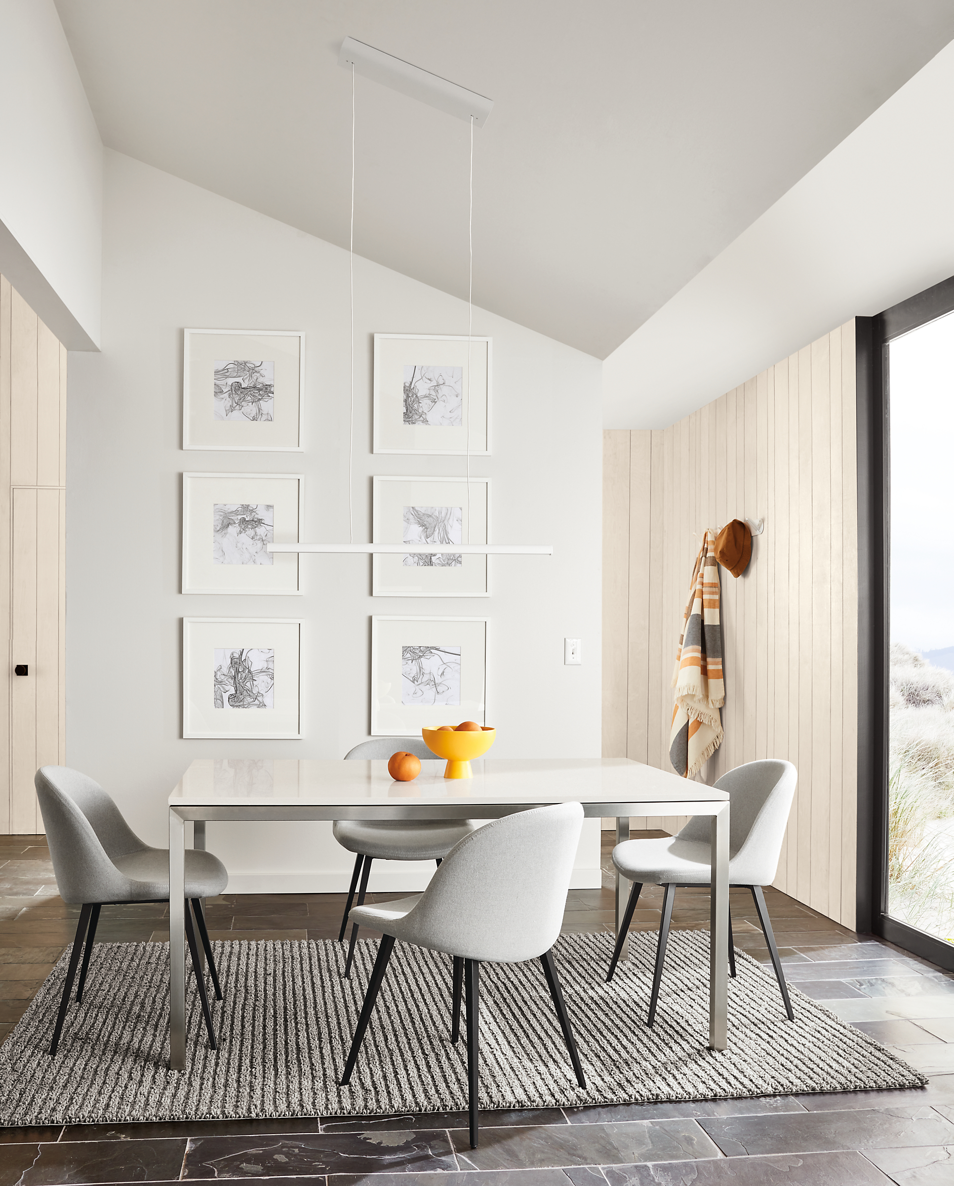 small dining room featuring parsons dining table with stainless steel base and light gray quartz top