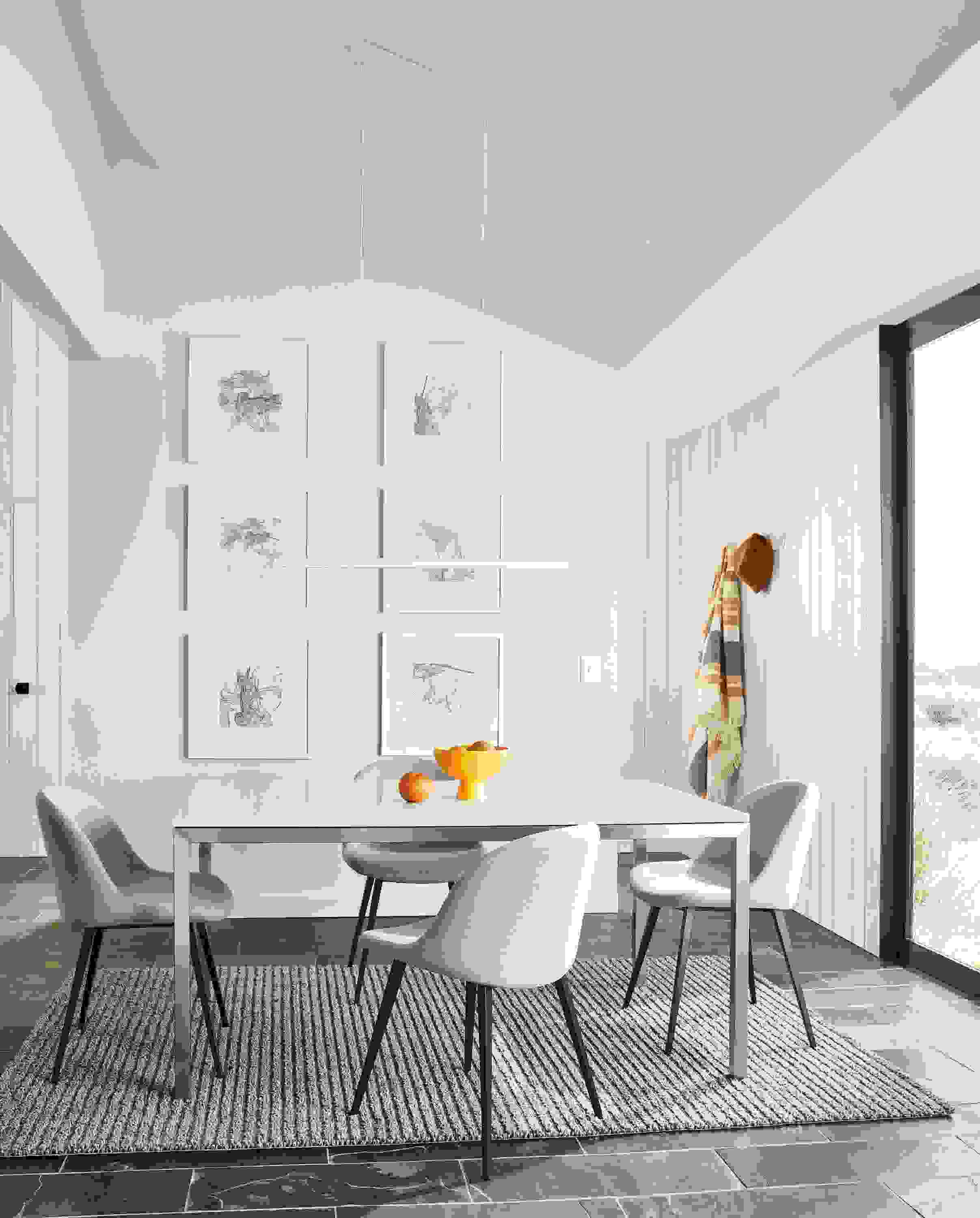 small dining room featuring parsons dining table with stainless steel base and light gray quartz top
