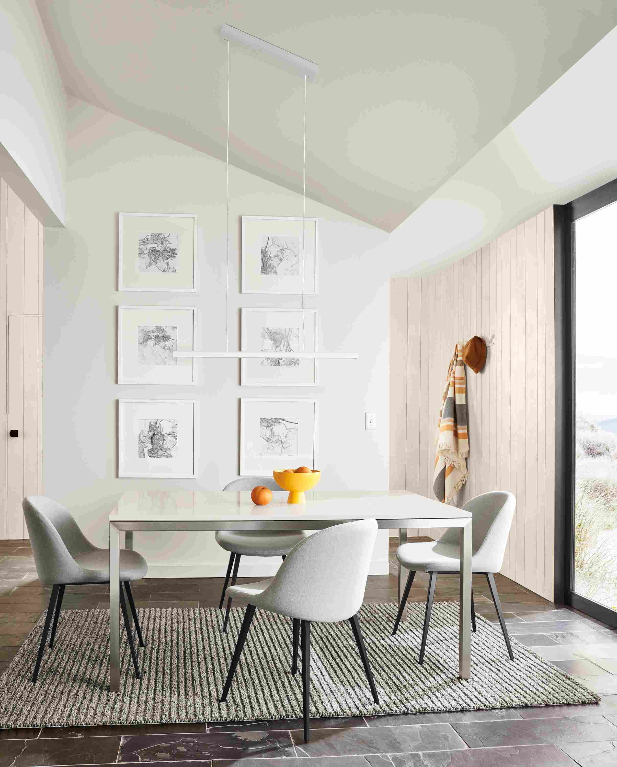 small dining room featuring parsons dining table with stainless steel base and light gray quartz top