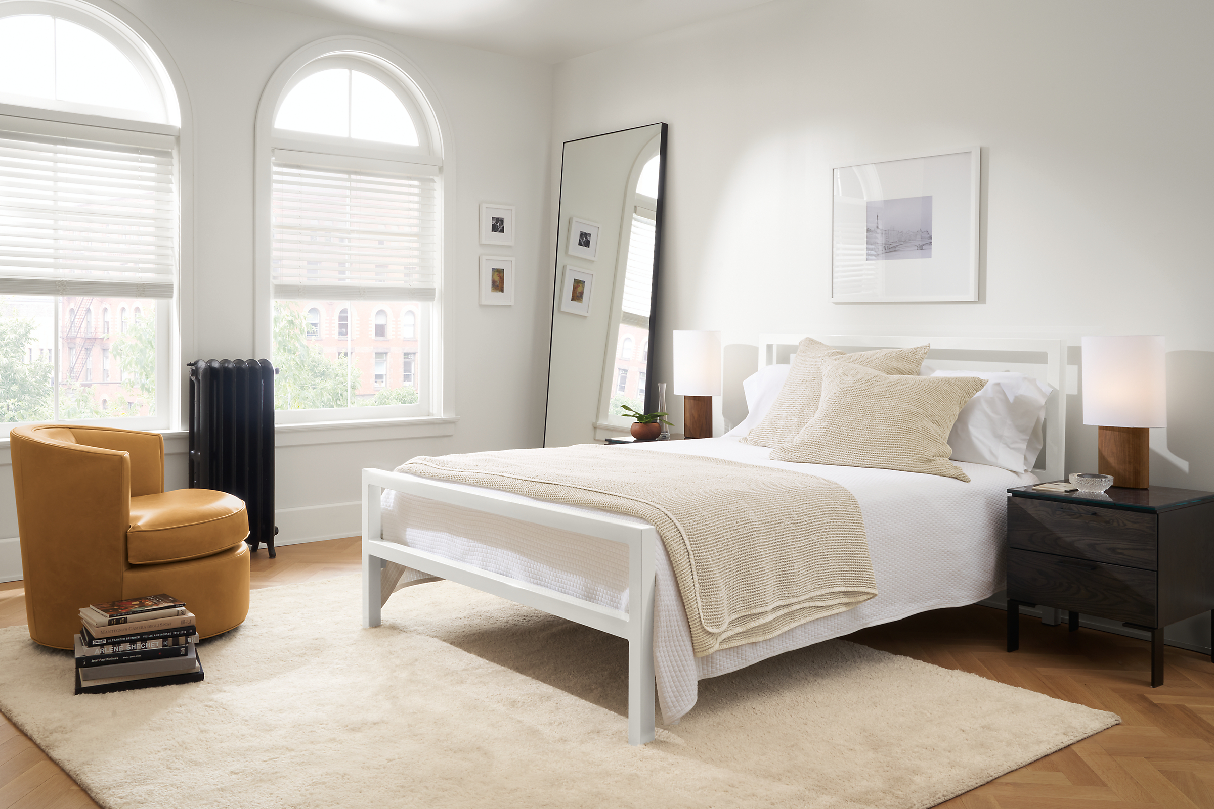 bedroom with parsons bed in white, otis leather swivel chair, aram rug.