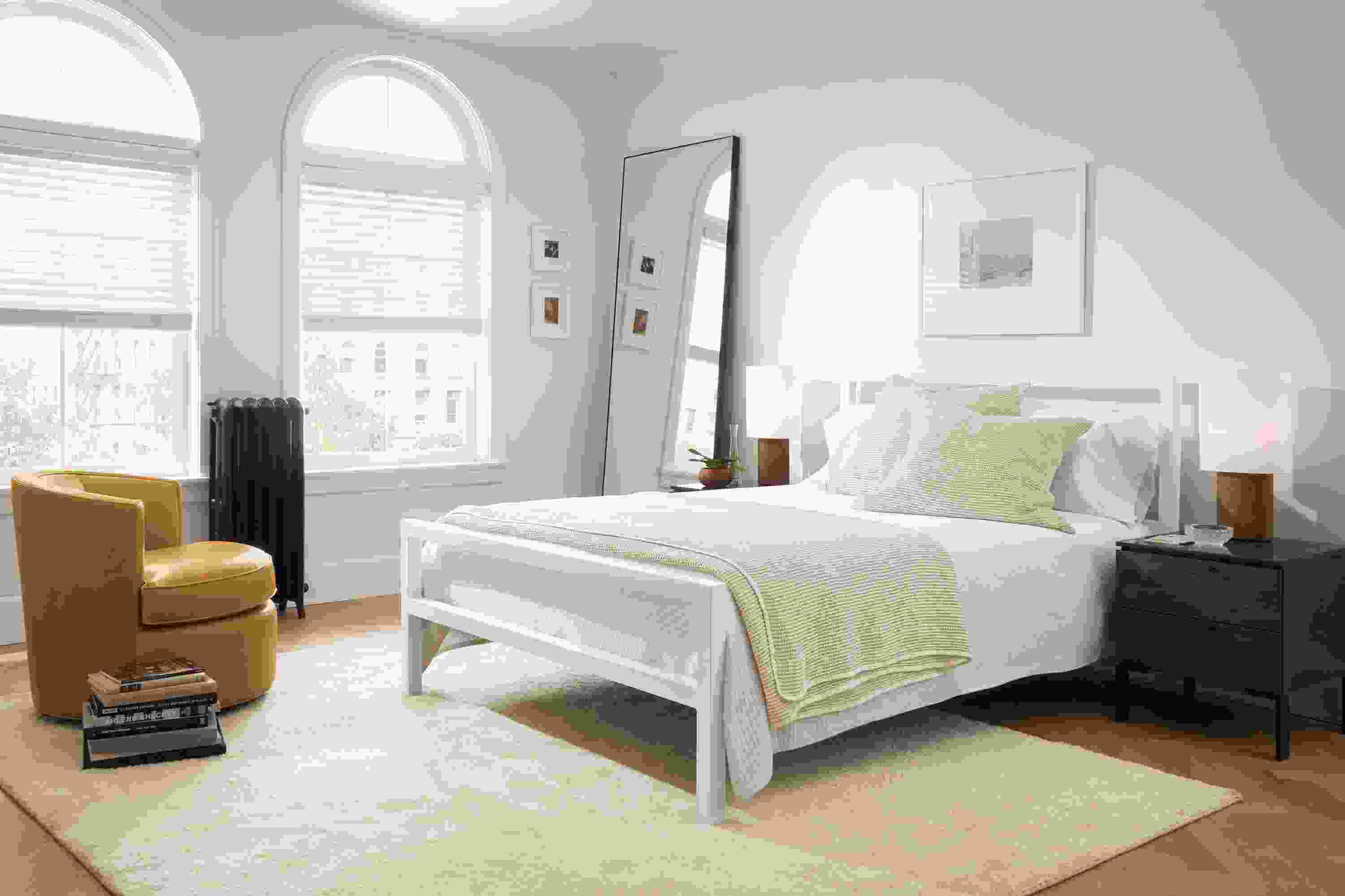 Bedroom with Parsons bed in white, Otis leather swivel chair in Vento Camel and Aram rug in ecru.