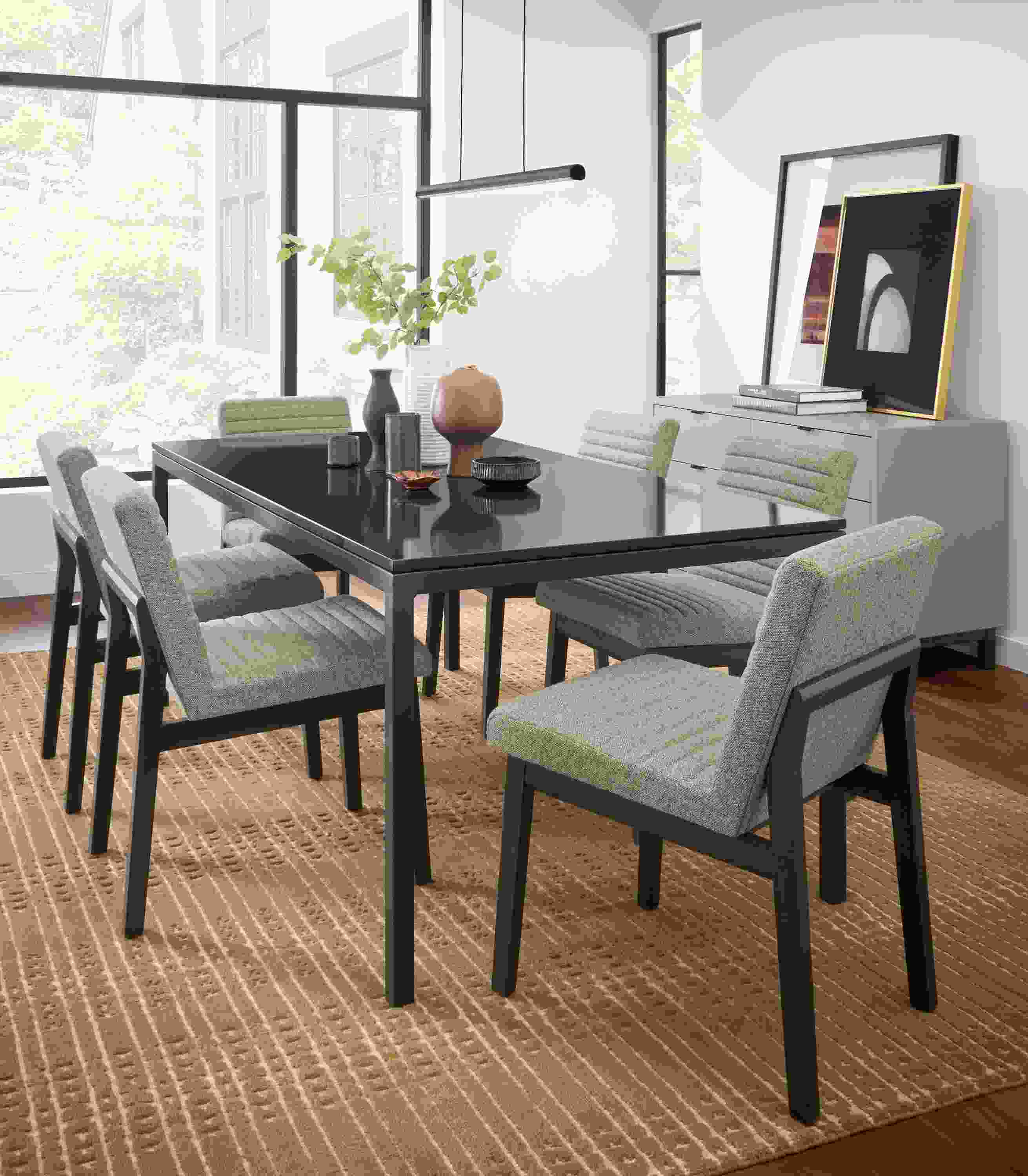 Dining room setting with Parsons 72-wide table in natural steel with black quartz top and Olsen side chairs in Tatum grey.