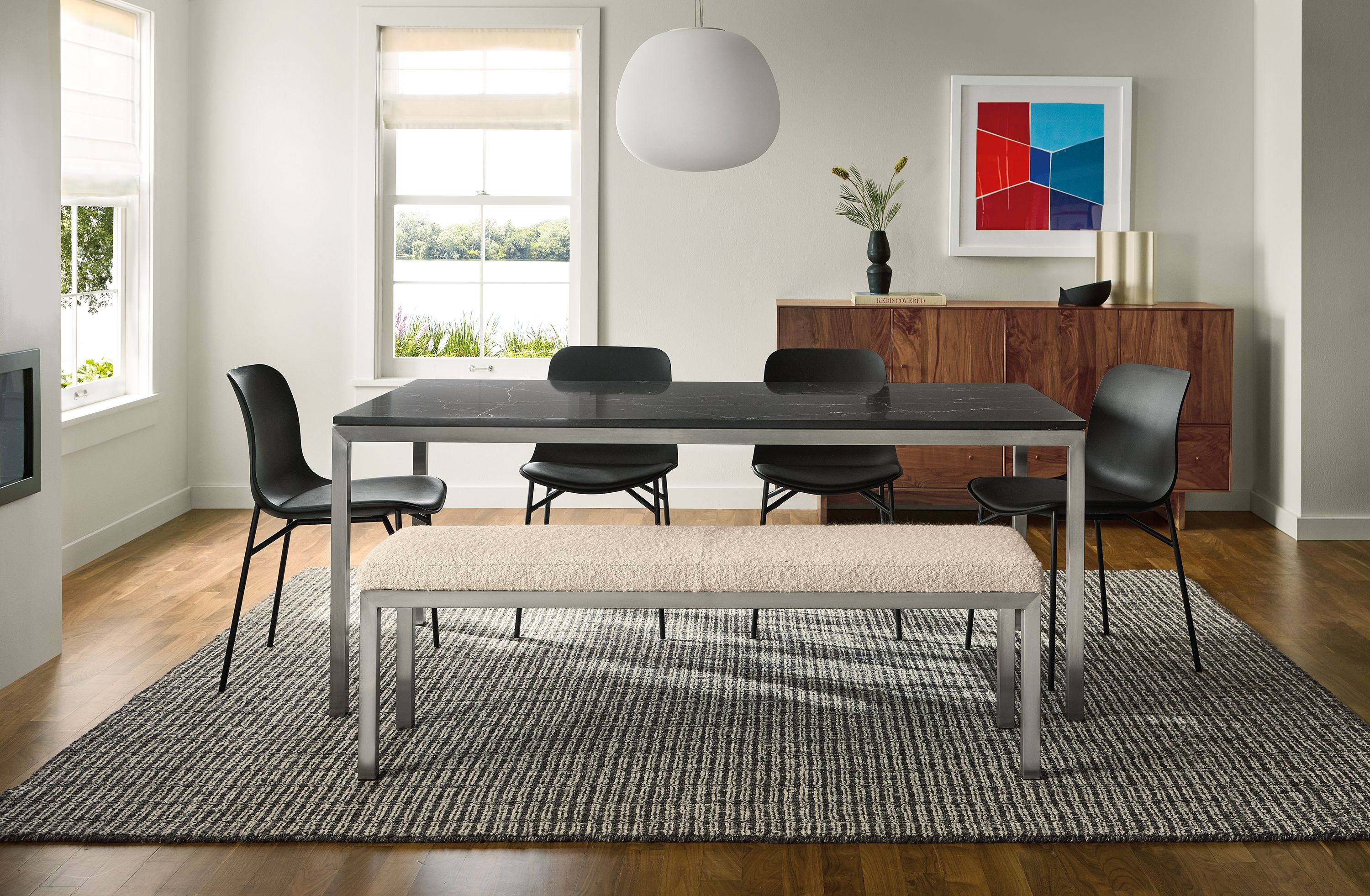 Dining room with Parsons 72-wide table in stainless steel with marbled black quartz and 4 pasqual side chairs in sarno black leather.