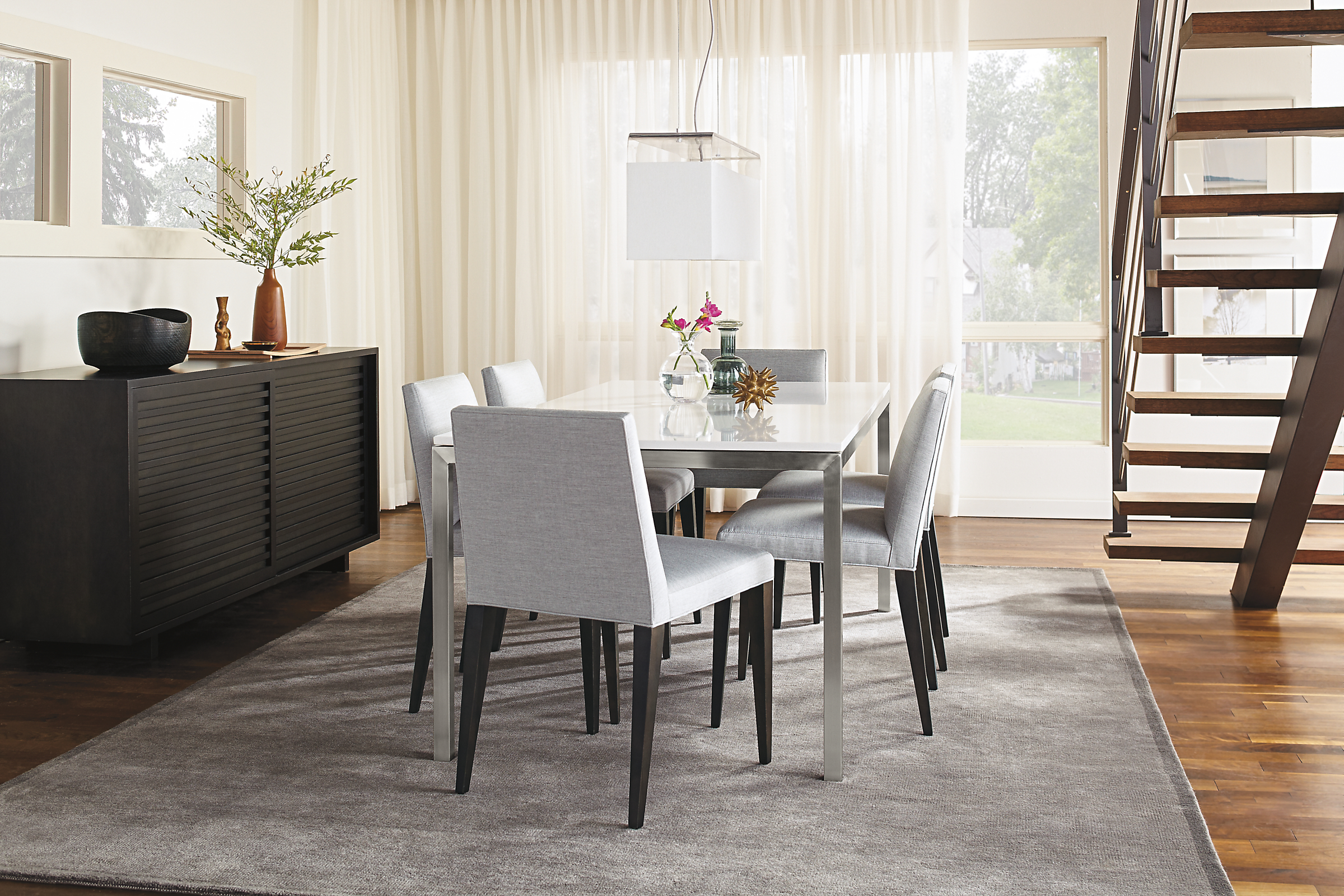Detail of Parsons stainless steel dining table with stainless steel base and white quartz top.