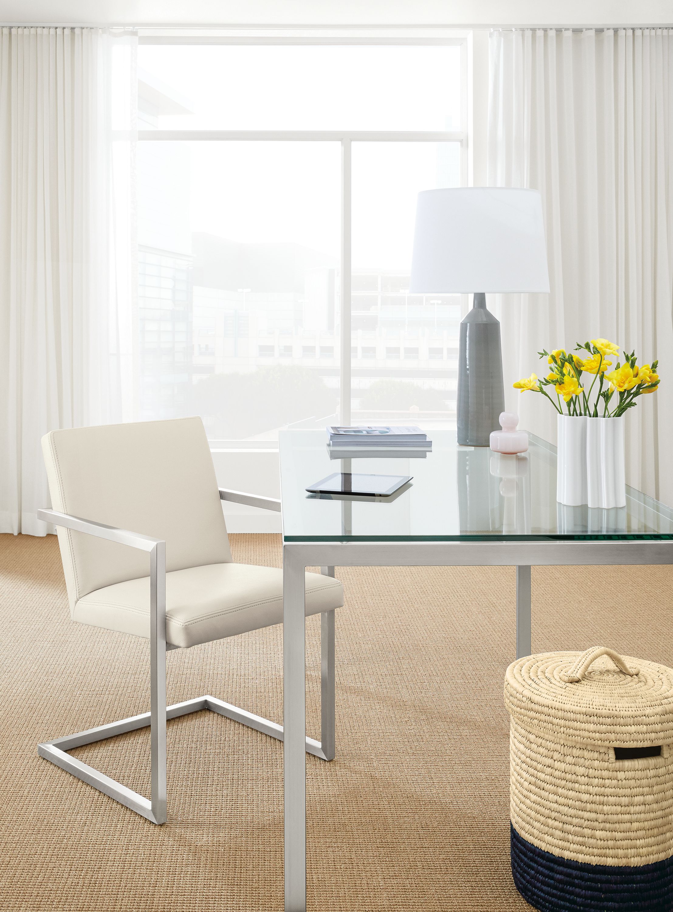 Office with Lira arm chair in Laino bone leather and Parsons table in stainless steel with glass top.