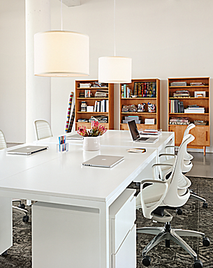 Office setting with 60-wide by 30-deep parsons table with legs in white and luce office chairs.