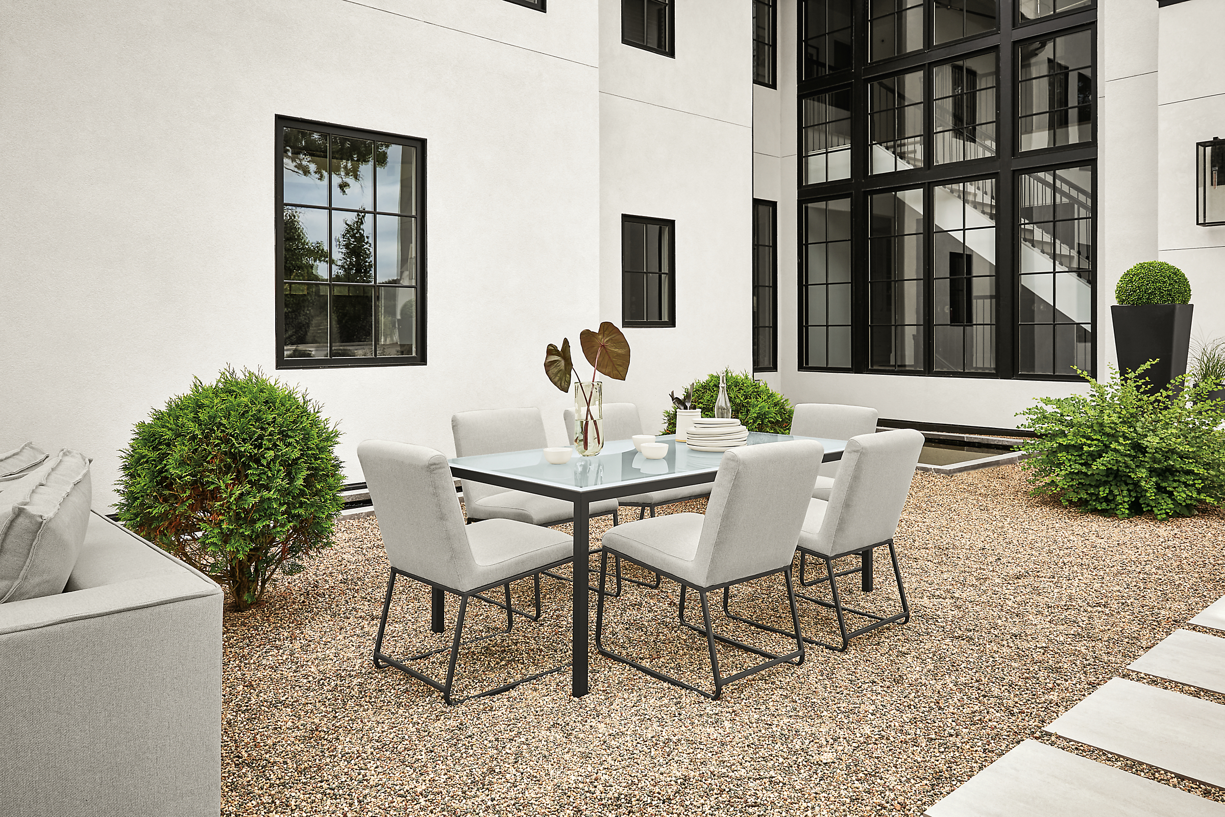 Outdoor setting with parsons 72-wide by 36-deep table with graphite legs and glass top.