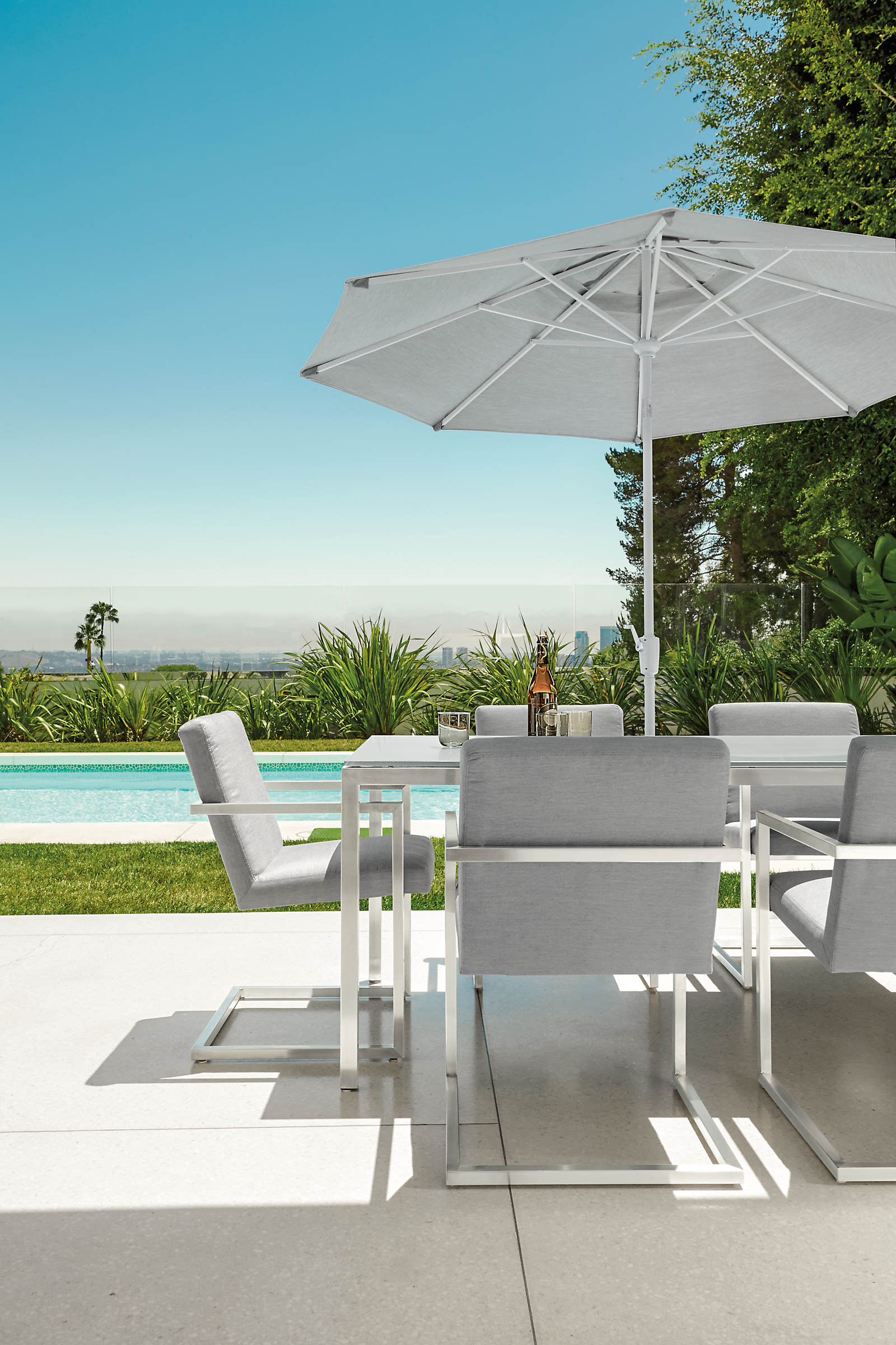 Outdoor setting with parsons 72-wide by 36-deep outdoor table in stainless steel with finn dining chairs.