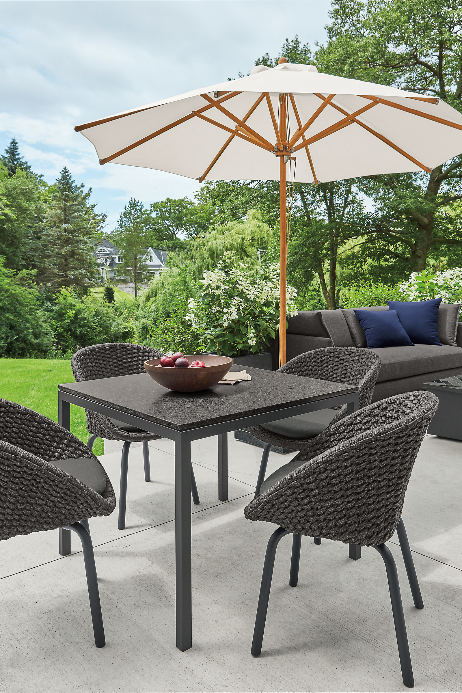 Outdoor setting with parsons outdoor table in graphite with flet side chairs and cirro patio umbrella.